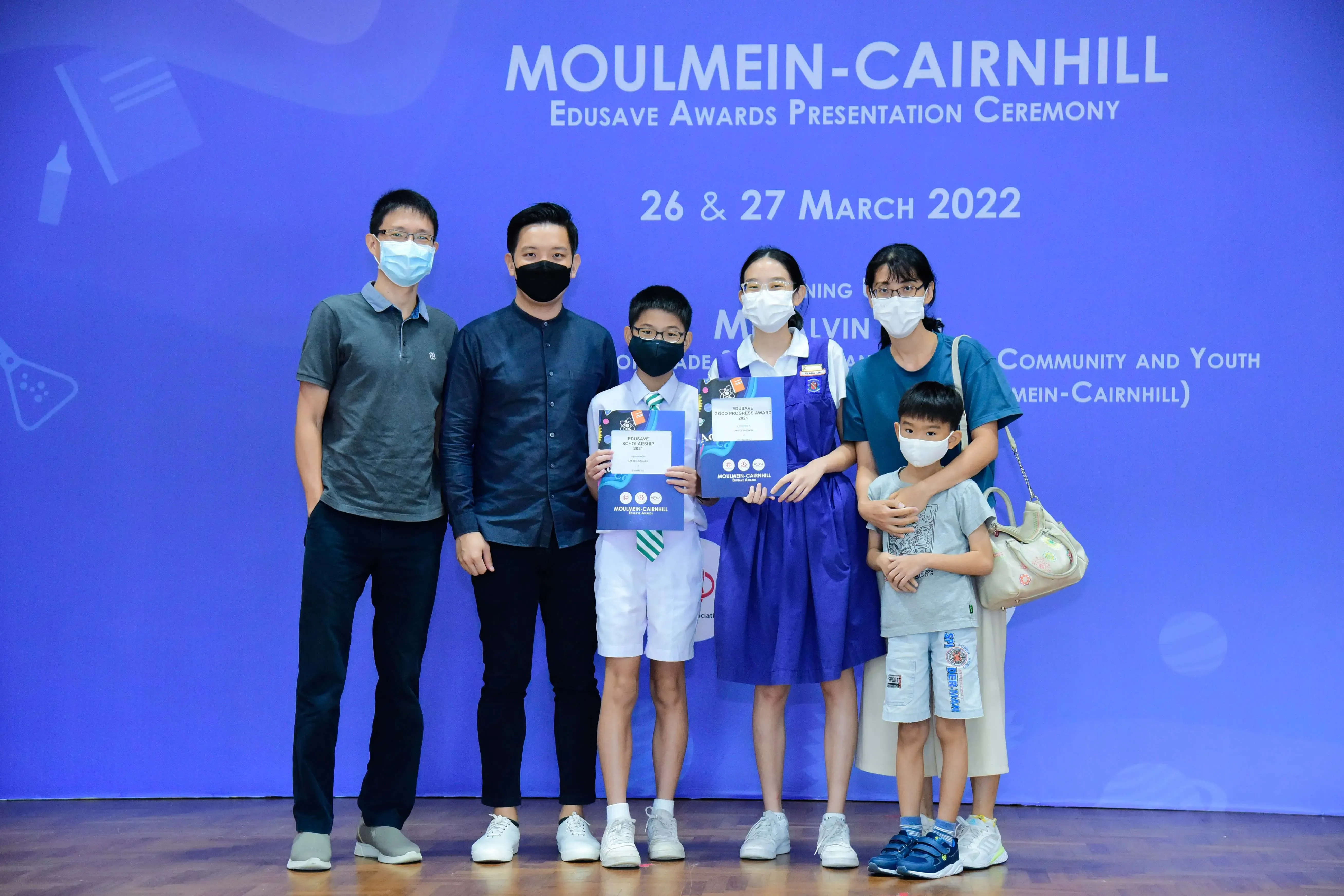 Six masked people pose at the Moulmein-Cairnhill Edusave Awards Presentation Ceremony on 26-27 March 2022.
