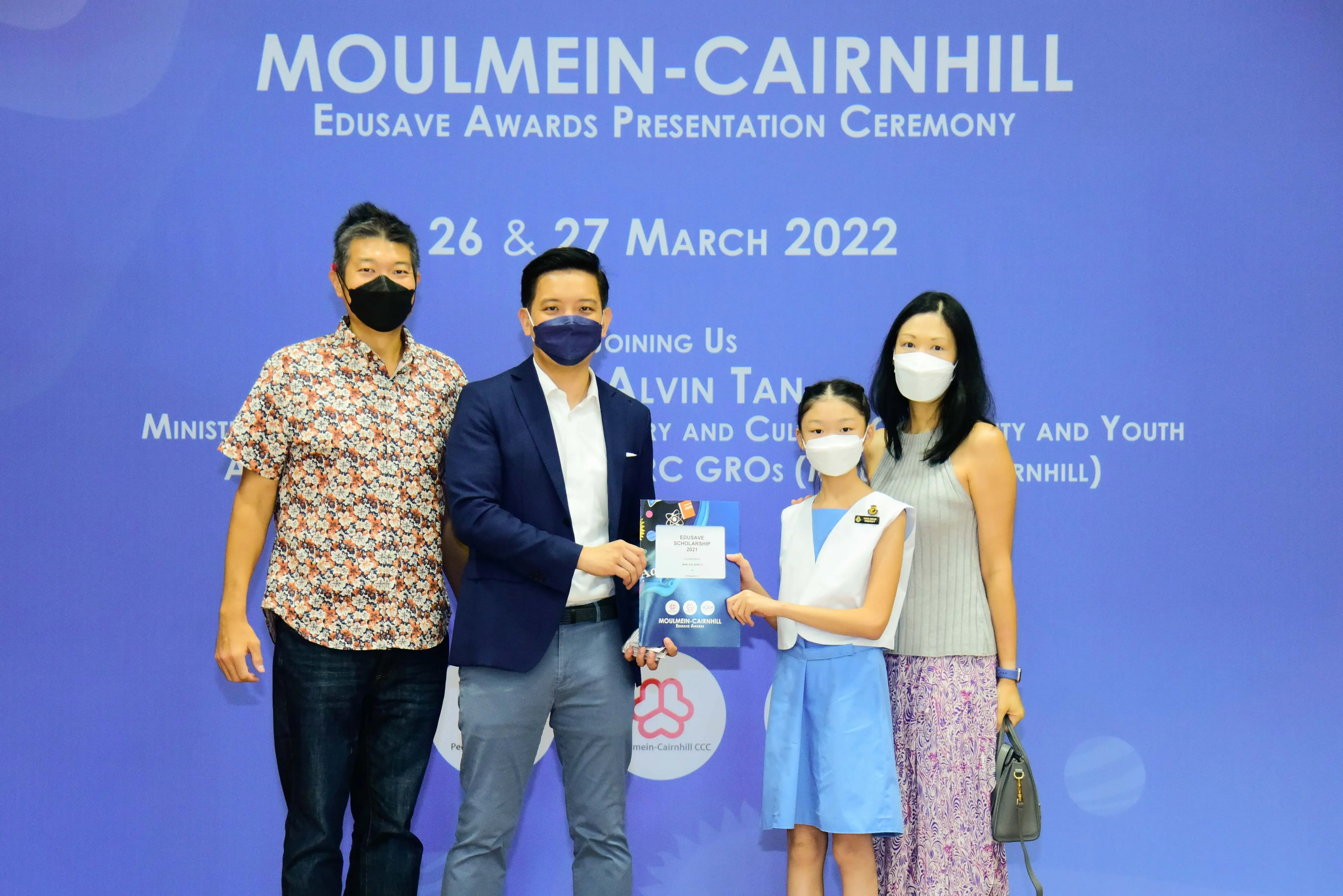 Four masked people pose at the Moulmein-Cairnhill Edusave Awards Presentation Ceremony on 26-27 March 2022.
