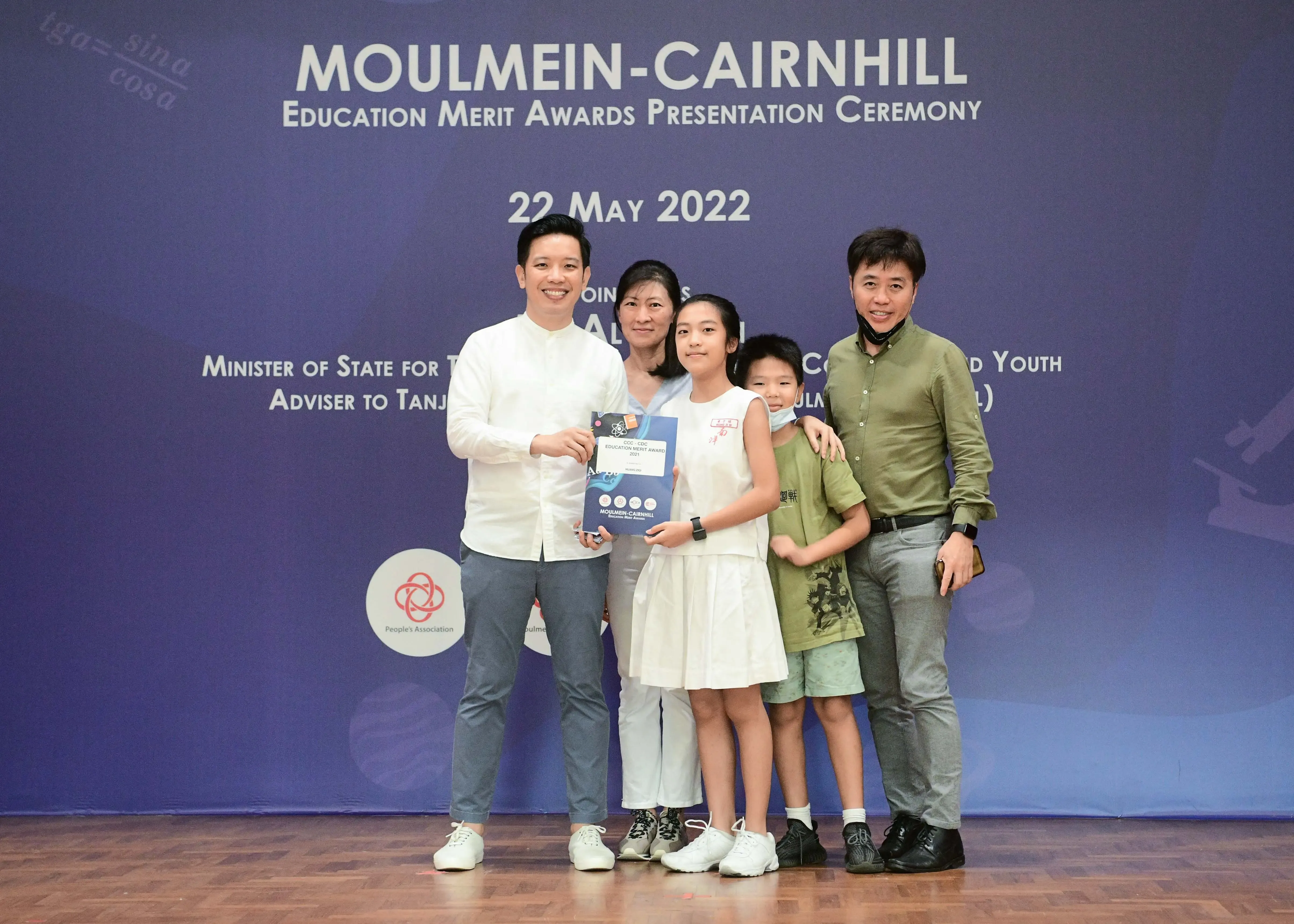 Five people pose with an award certificate at the Moulmein-Cairnhill Education Merit Awards Ceremony on 22 May 2022.