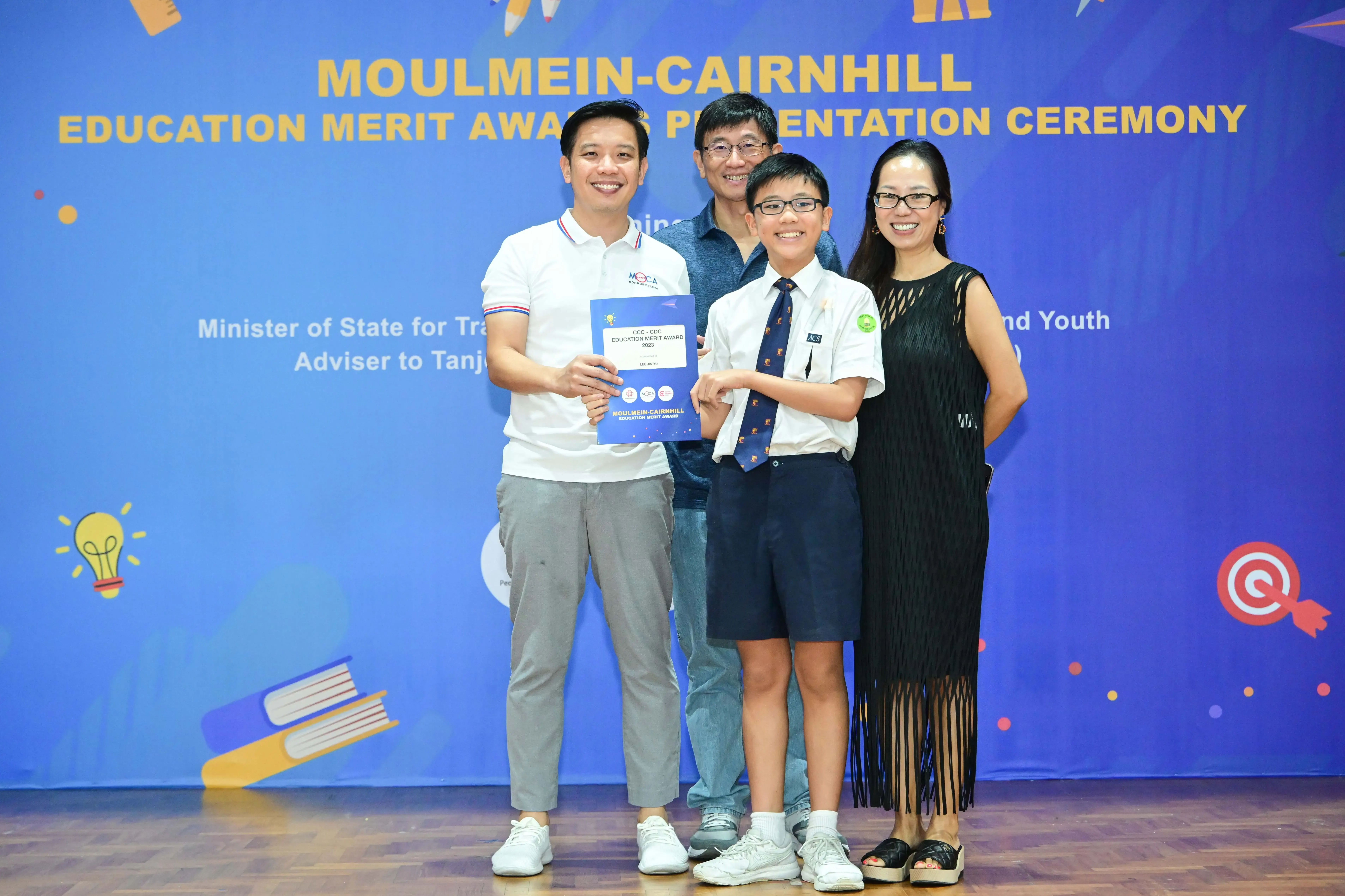 Four people pose with an award certificate at the Moulmein-Cairnhill Education Merit Awards Presentation Ceremony.