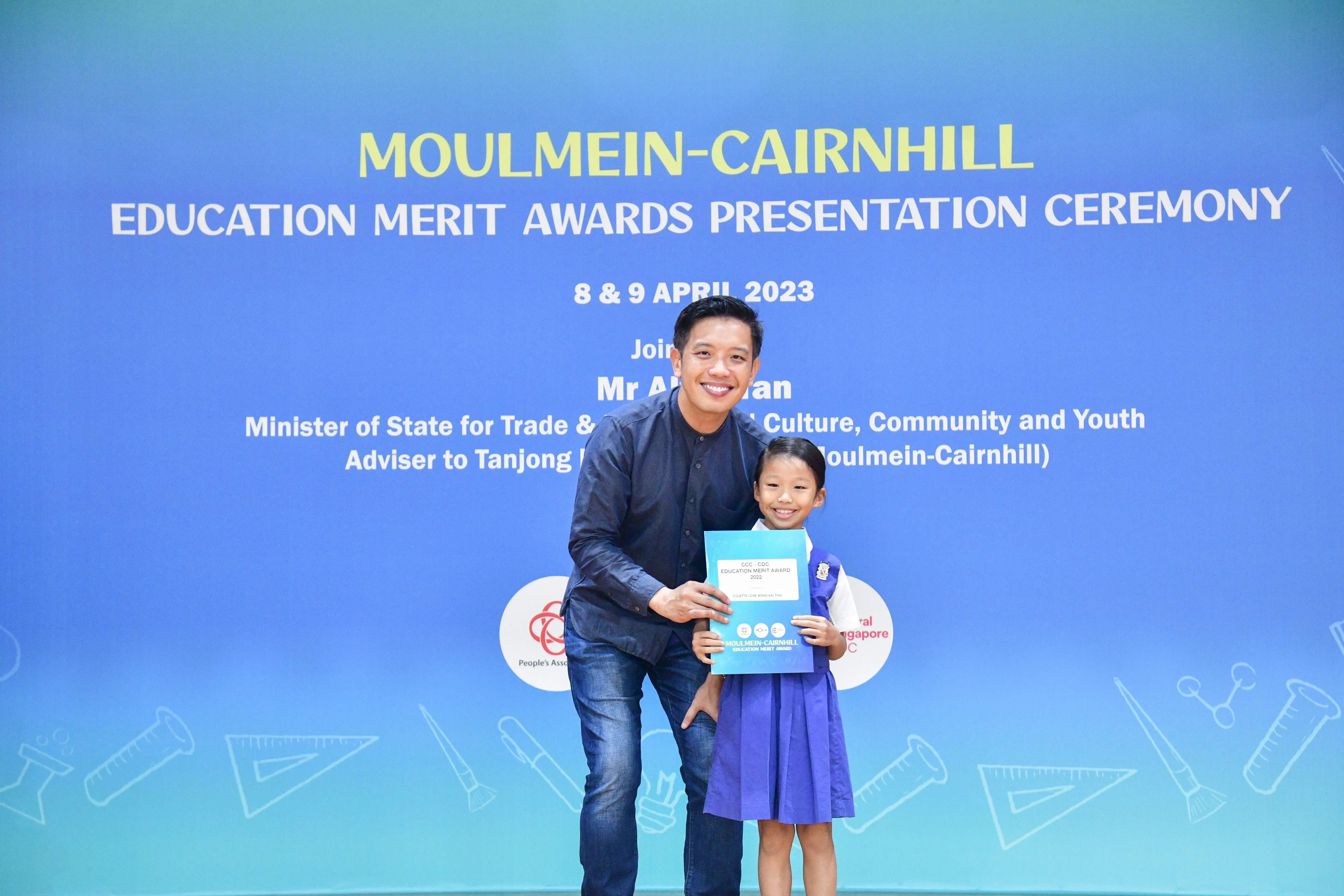 A man and a young girl holding an award certificate at the Moulmein-Cairnhill Education Merit Awards 2023.
