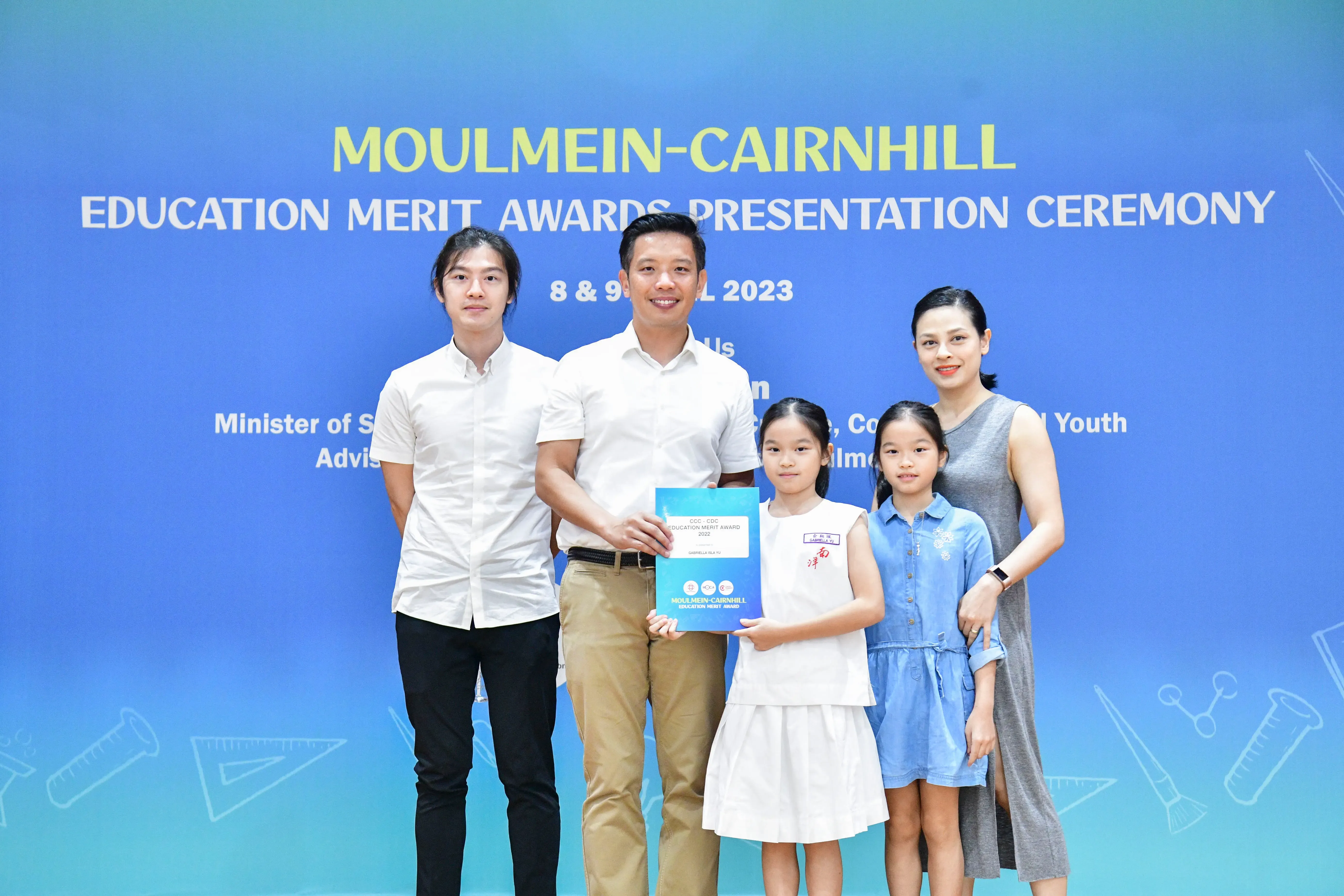Five people pose at the Moulmein-Cairnhill Education Merit Awards Presentation Ceremony 2023, holding an award certificate.