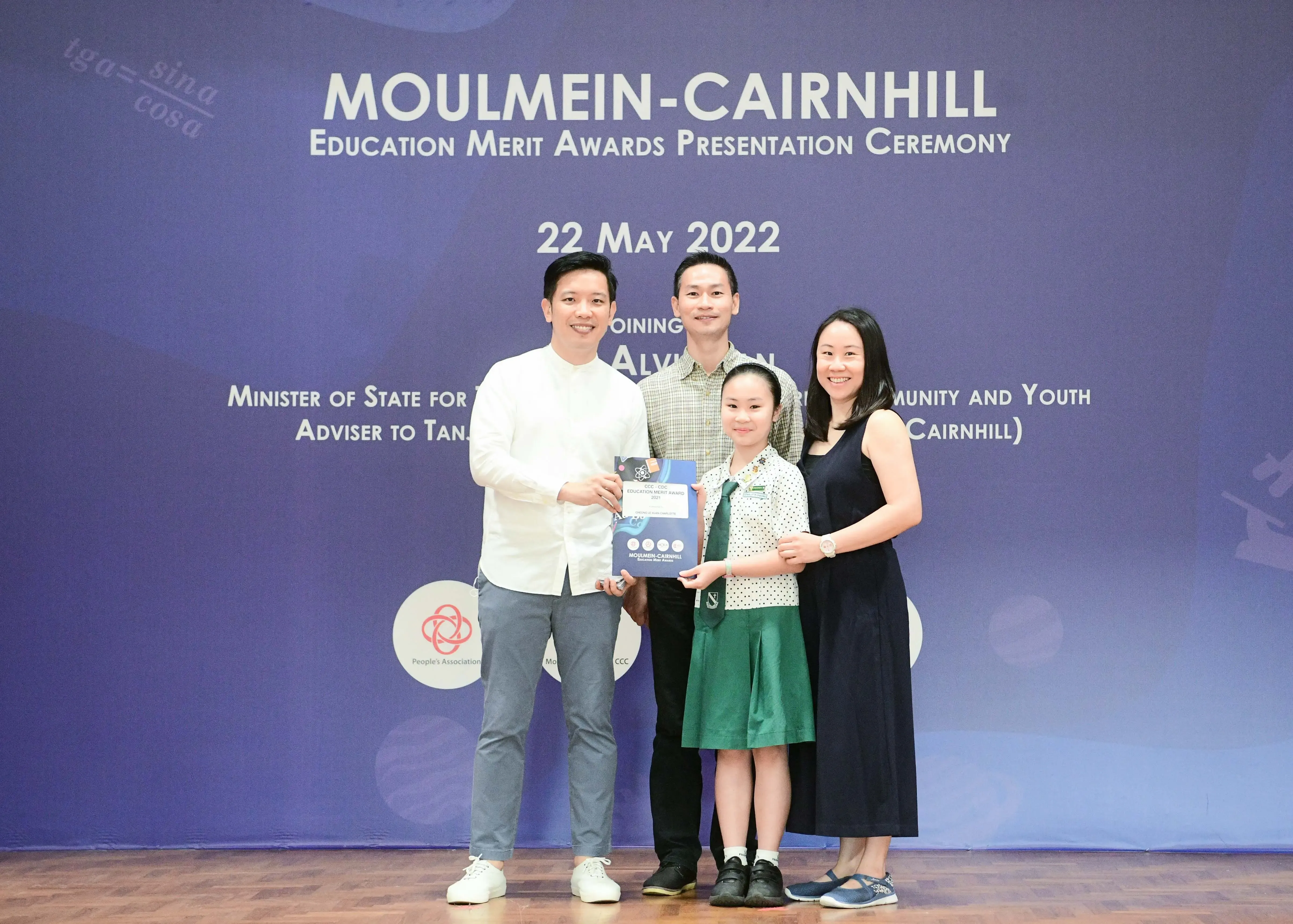 Four people pose with an award at the Moulmein-Cairnhill Education Merit Awards Ceremony on 22 May 2022.