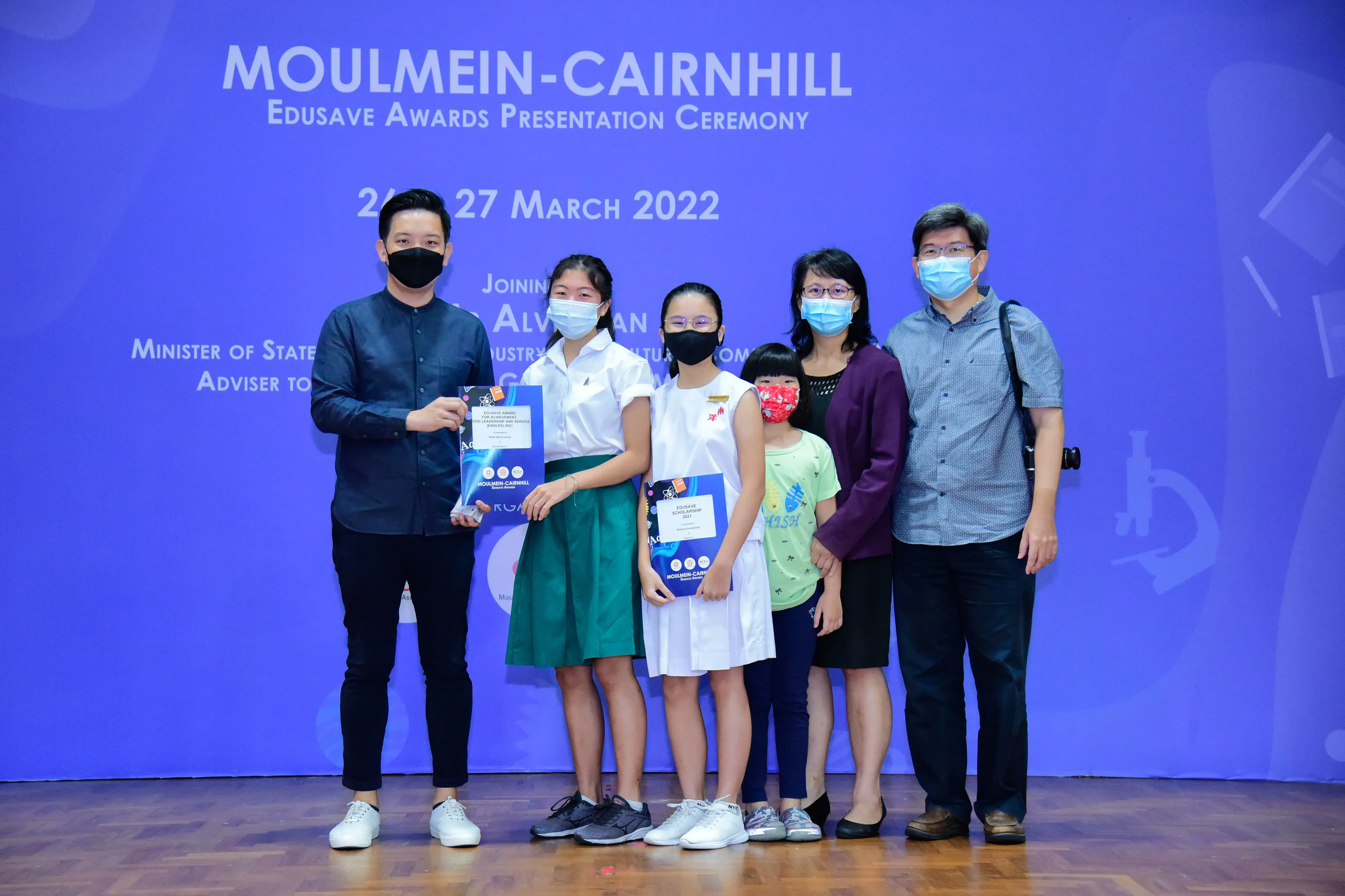 Six masked people posing at the Moulmein-Cairnhill Edusave Awards Presentation Ceremony on 26-27 March 2022.