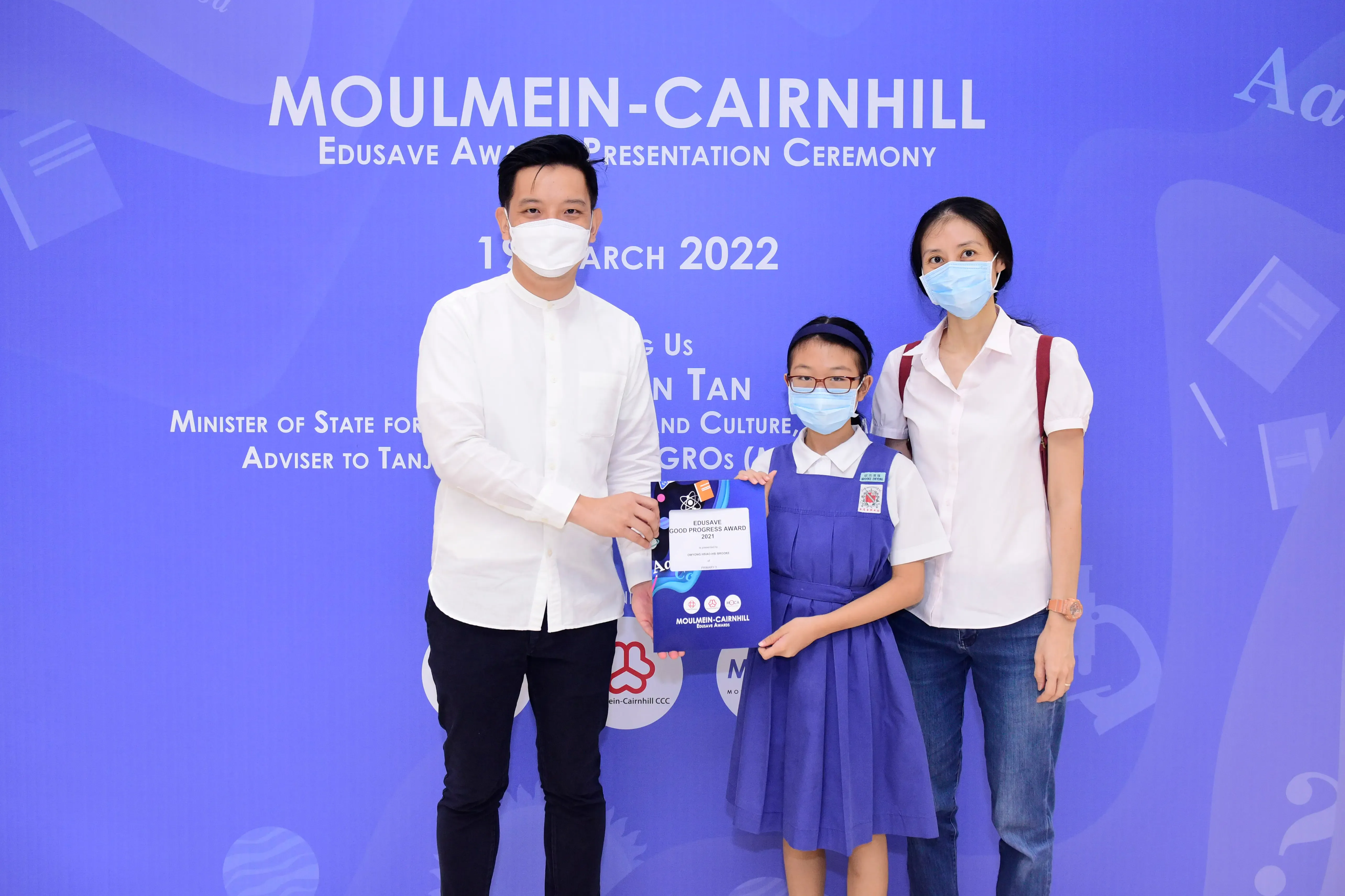 Three masked people pose at the Moulmein-Cairnhill Edusave Award Presentation Ceremony on 19 March 2022.