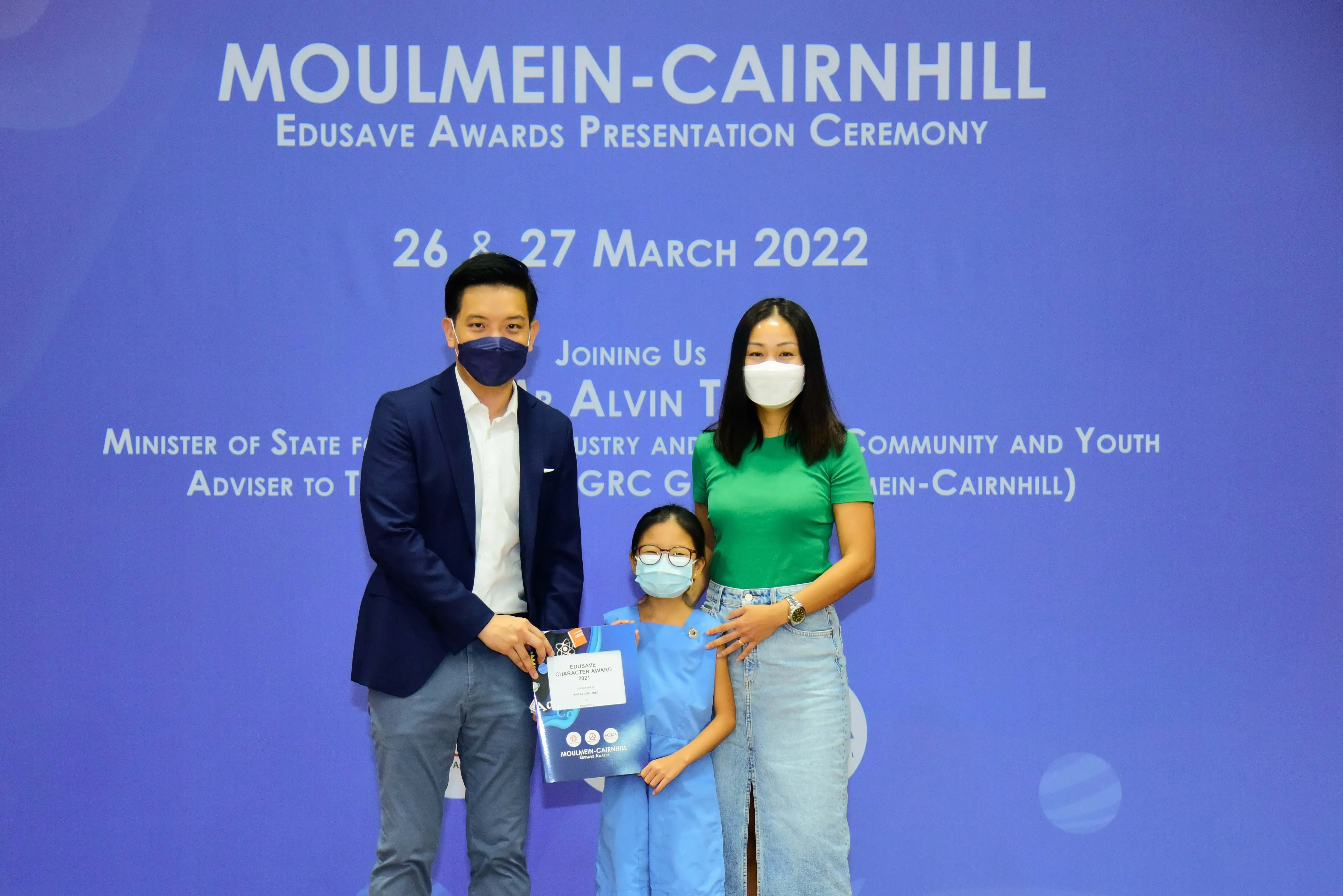 Three masked people pose at the Moulmein-Cairnhill Edusave Awards Presentation Ceremony on 26-27 March 2022.