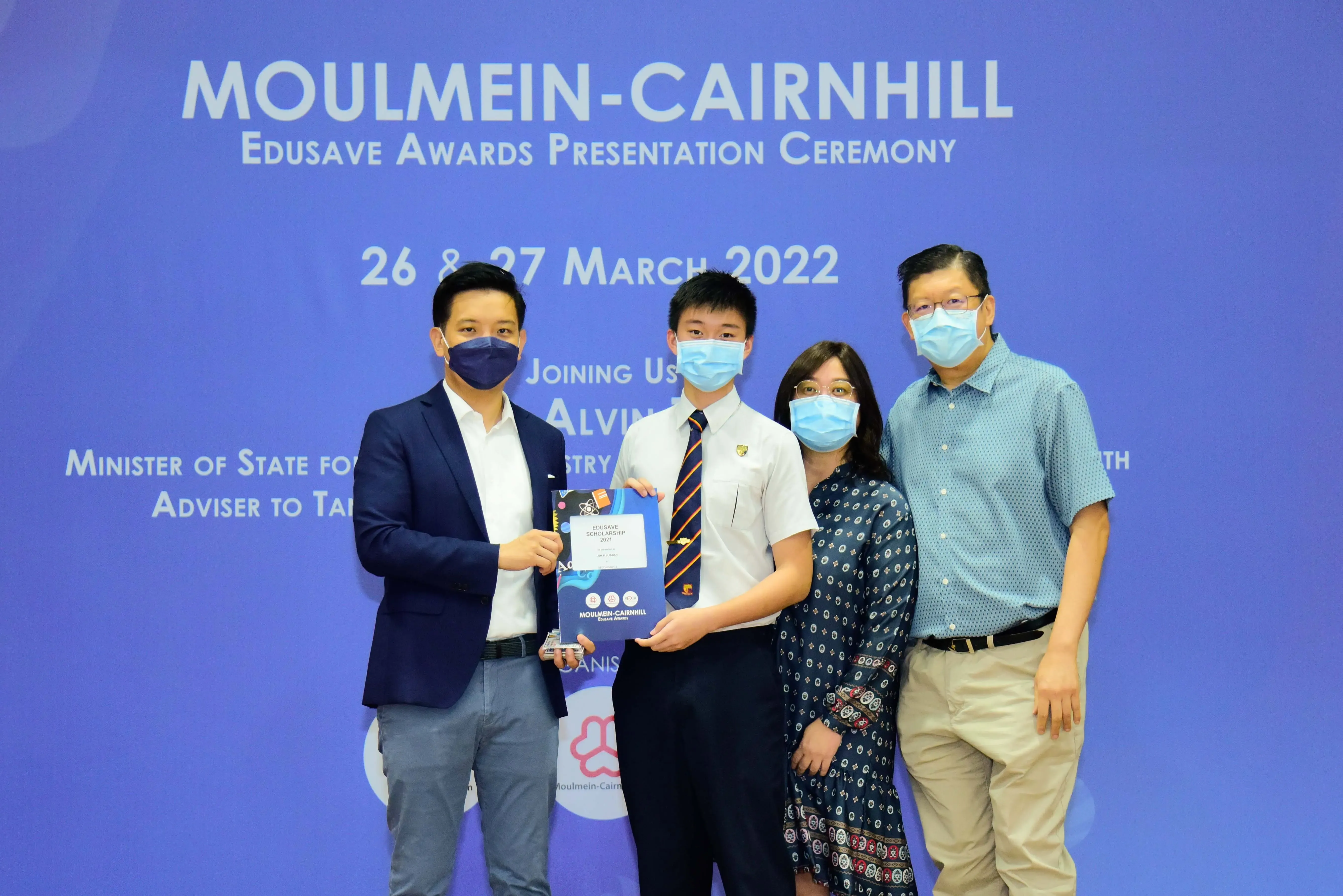 Four masked people pose at the Moulmein-Cairnhill Edusave Awards Presentation Ceremony on 26-27 March 2022.