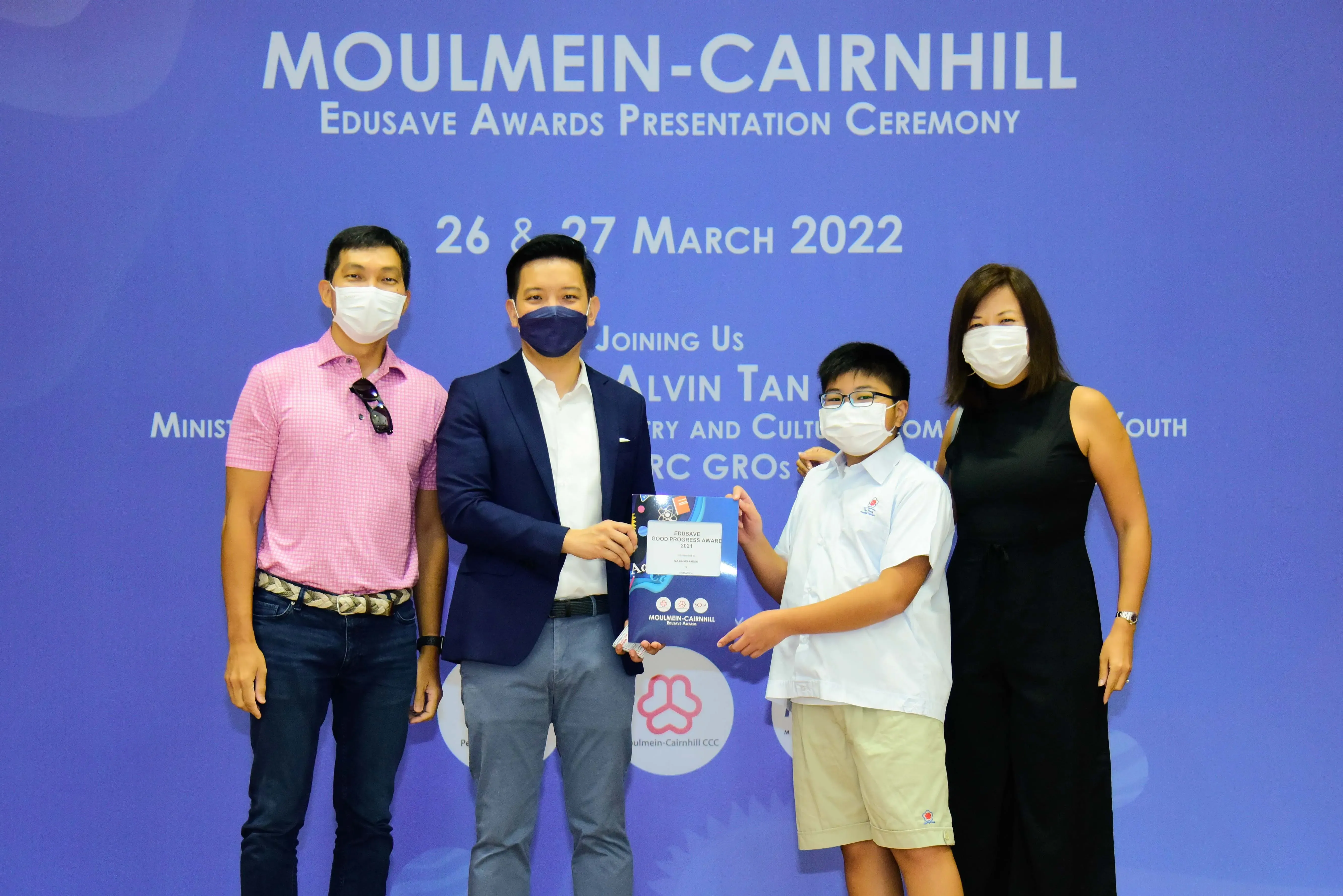 Four masked people pose at the Moulmein-Cairnhill Edusave Awards Presentation Ceremony on 26-27 March 2022.