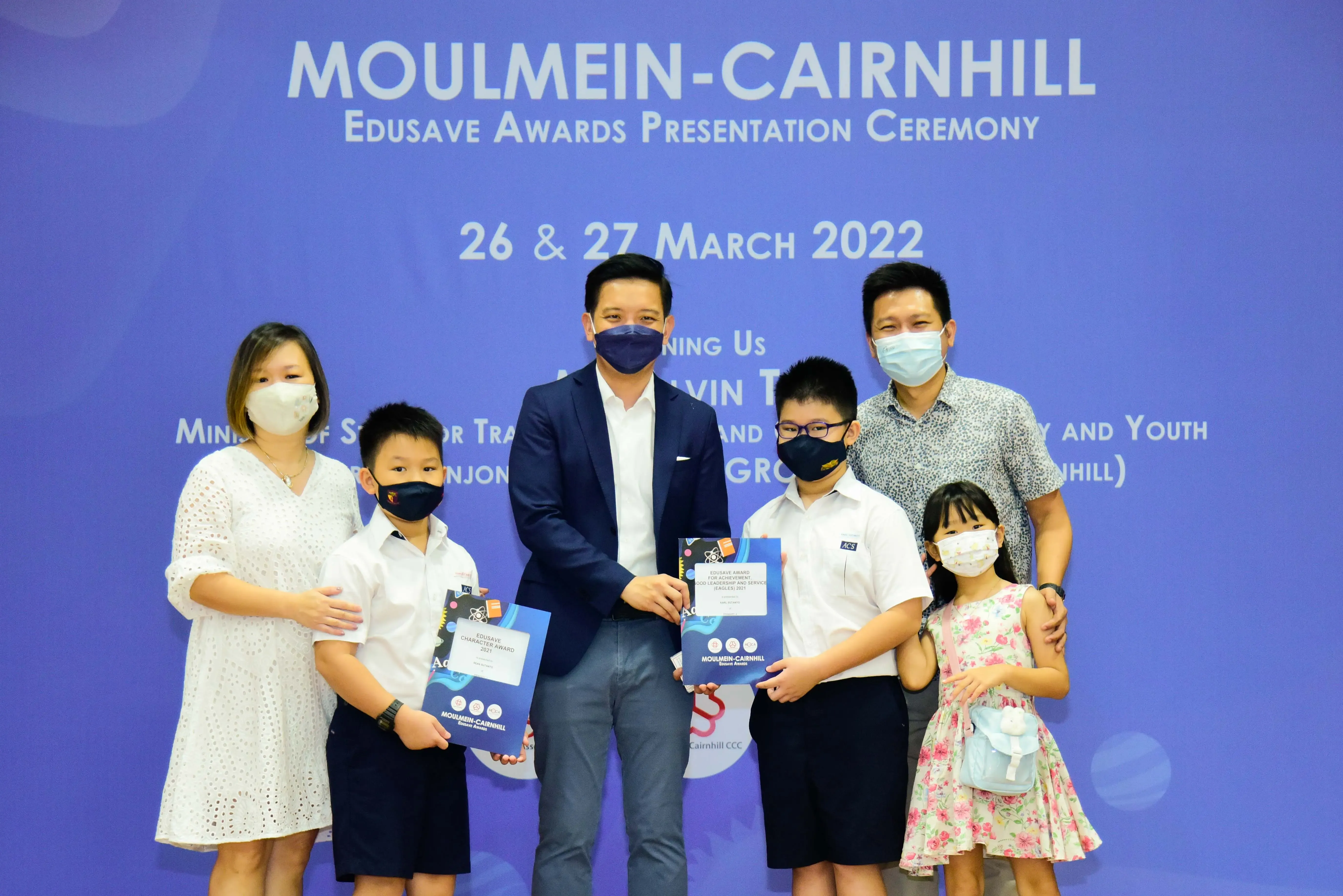 Six masked people pose at the Moulmein-Cairnhill Edusave Awards Presentation Ceremony on 26-27 March 2022.