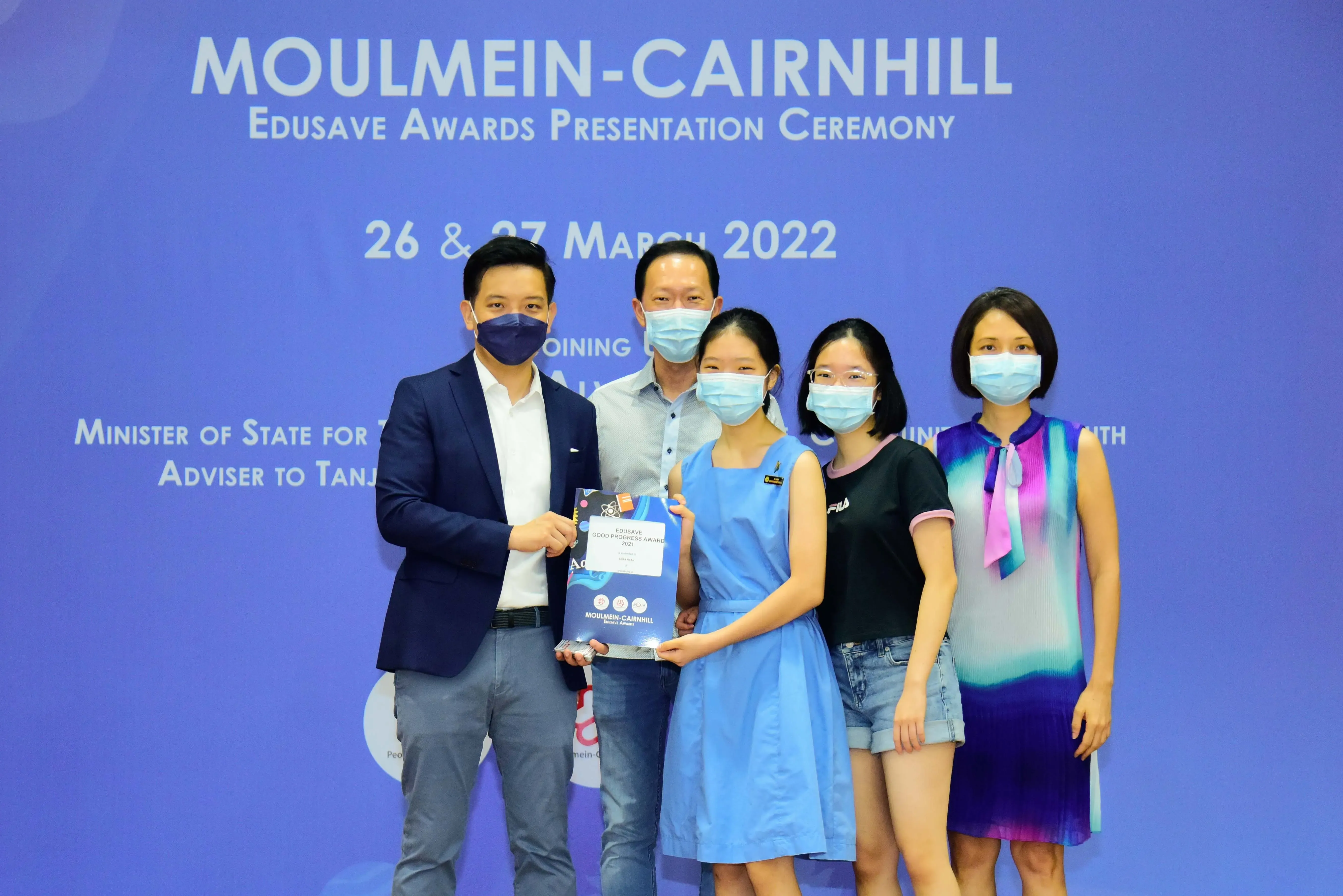 Five masked people pose at the Moulmein-Cairnhill Edusave Awards Presentation Ceremony on 26-27 March 2022.