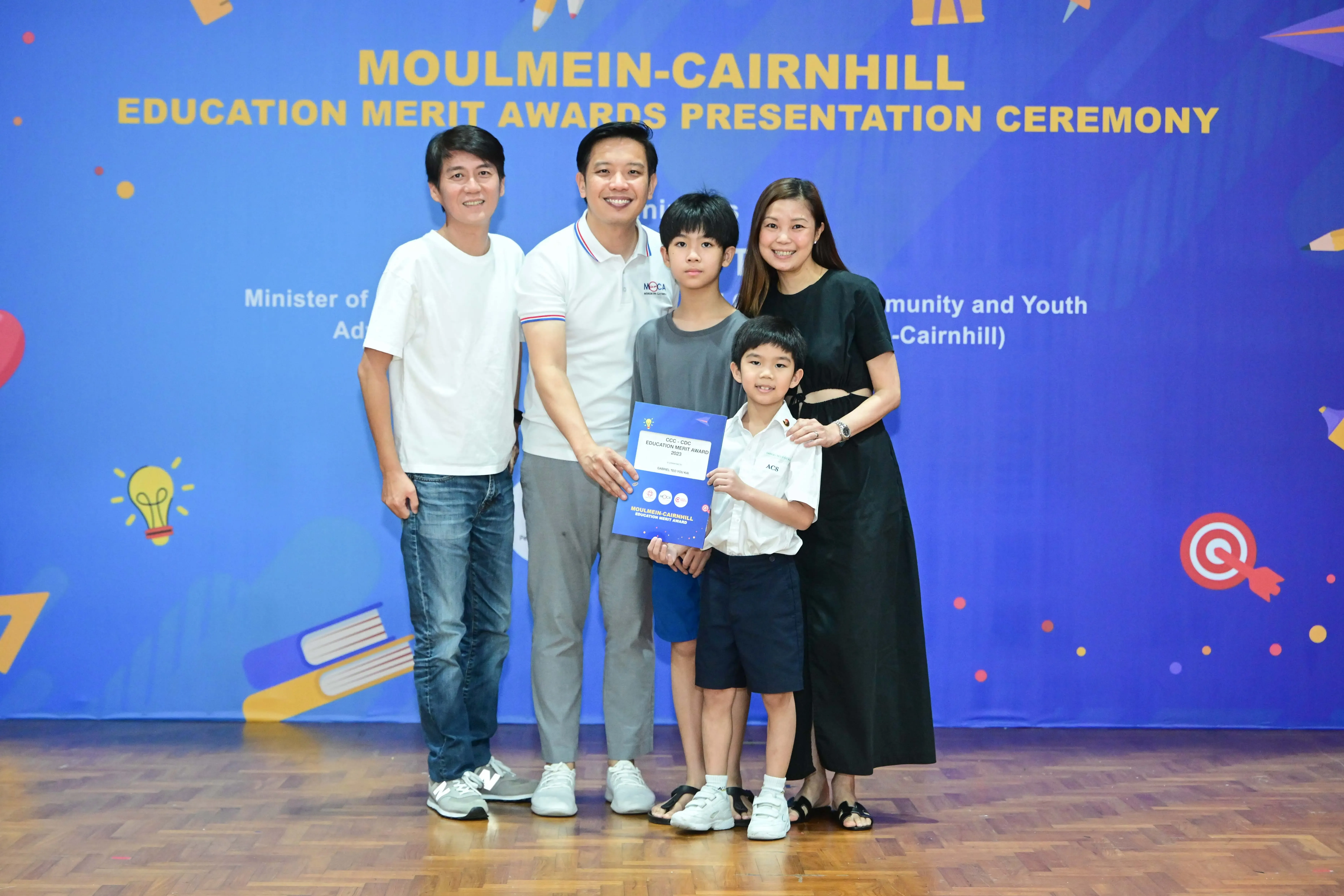 Five people pose with an award certificate at the Moulmein-Cairnhill Education Merit Awards Presentation Ceremony.
