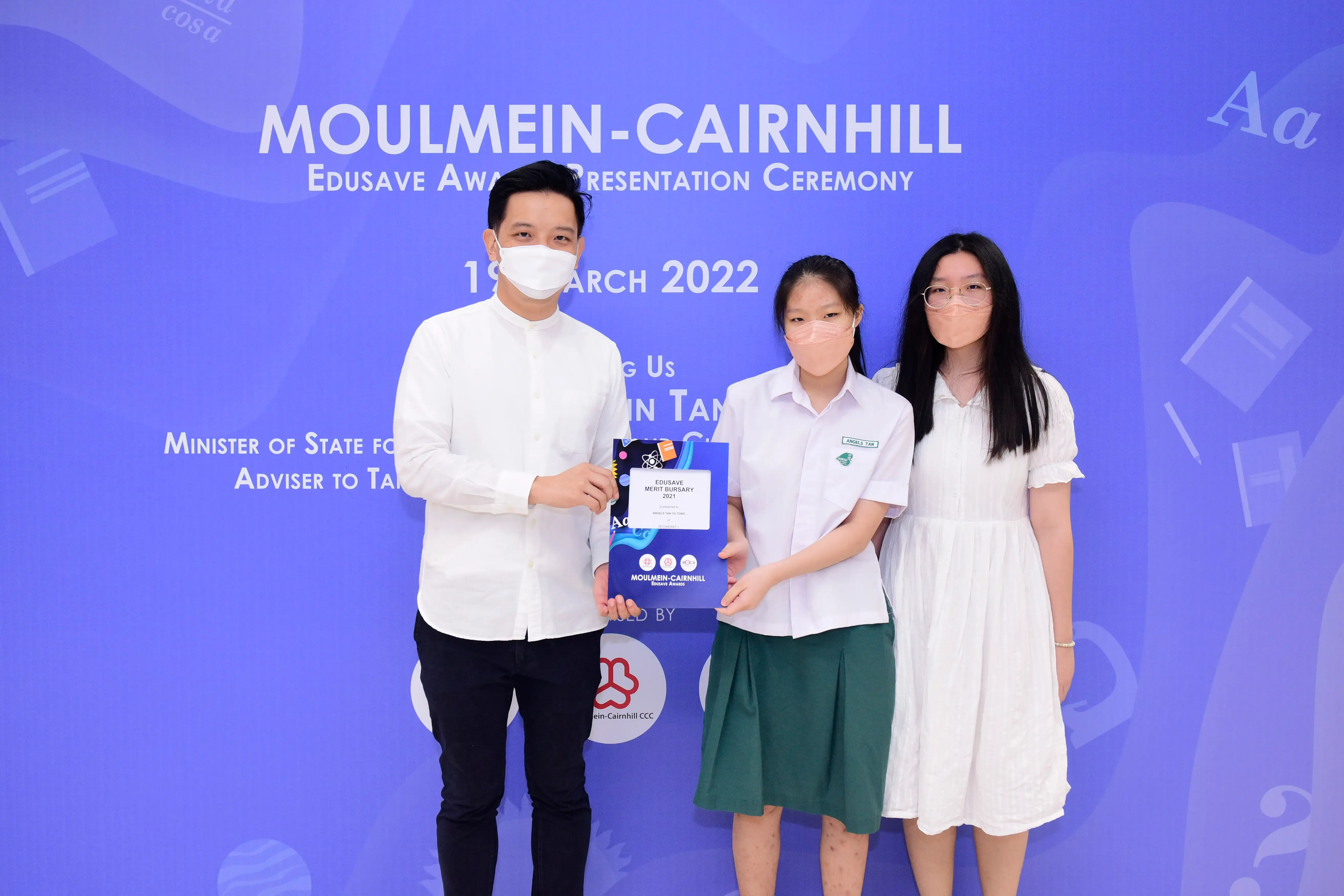 Three masked people pose at the Moulmein-Cairnhill Edusave Award Presentation Ceremony on 19 March 2022.
