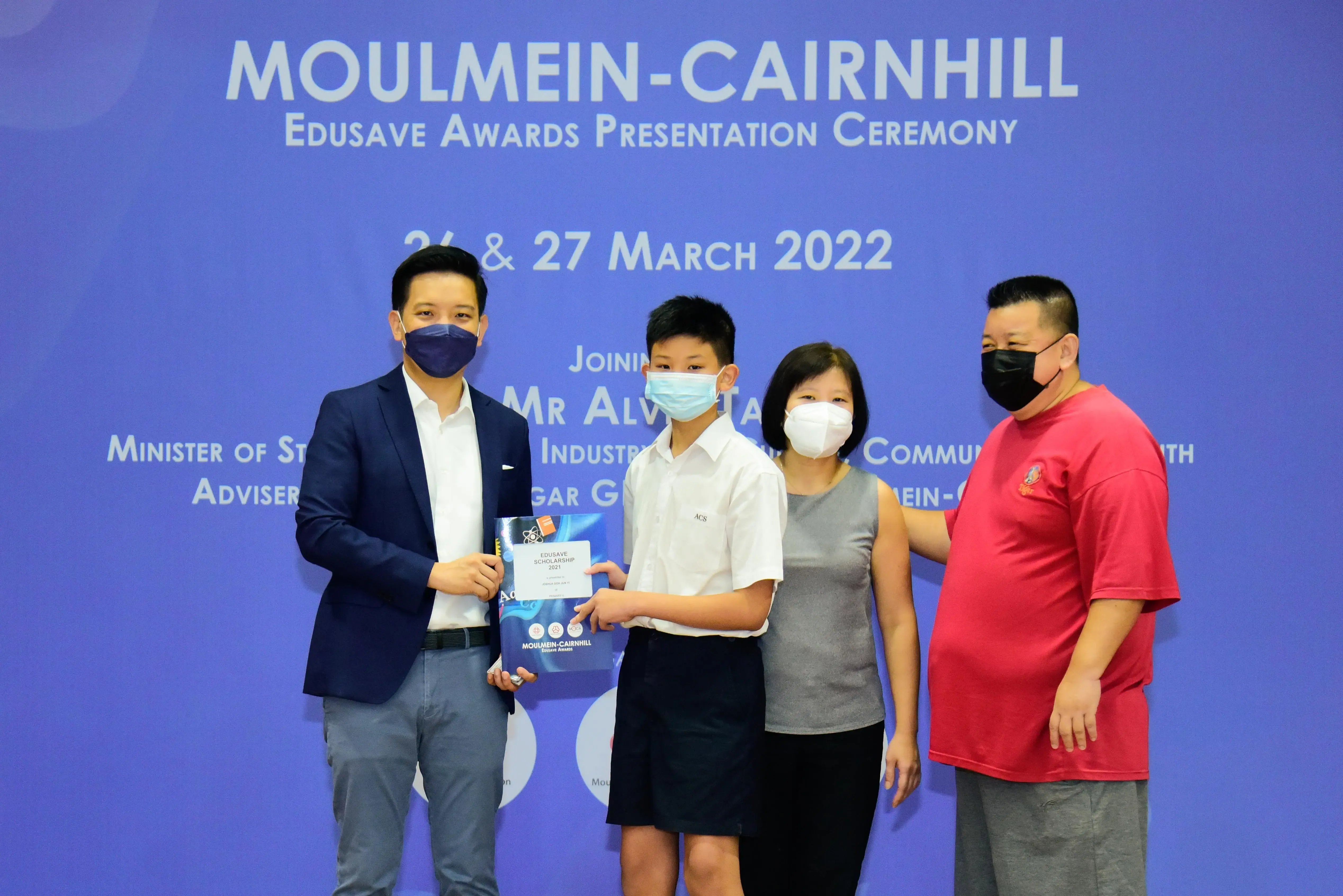 Four masked people pose at the Moulmein-Cairnhill Edusave Awards Presentation Ceremony on 26-27 March 2022.