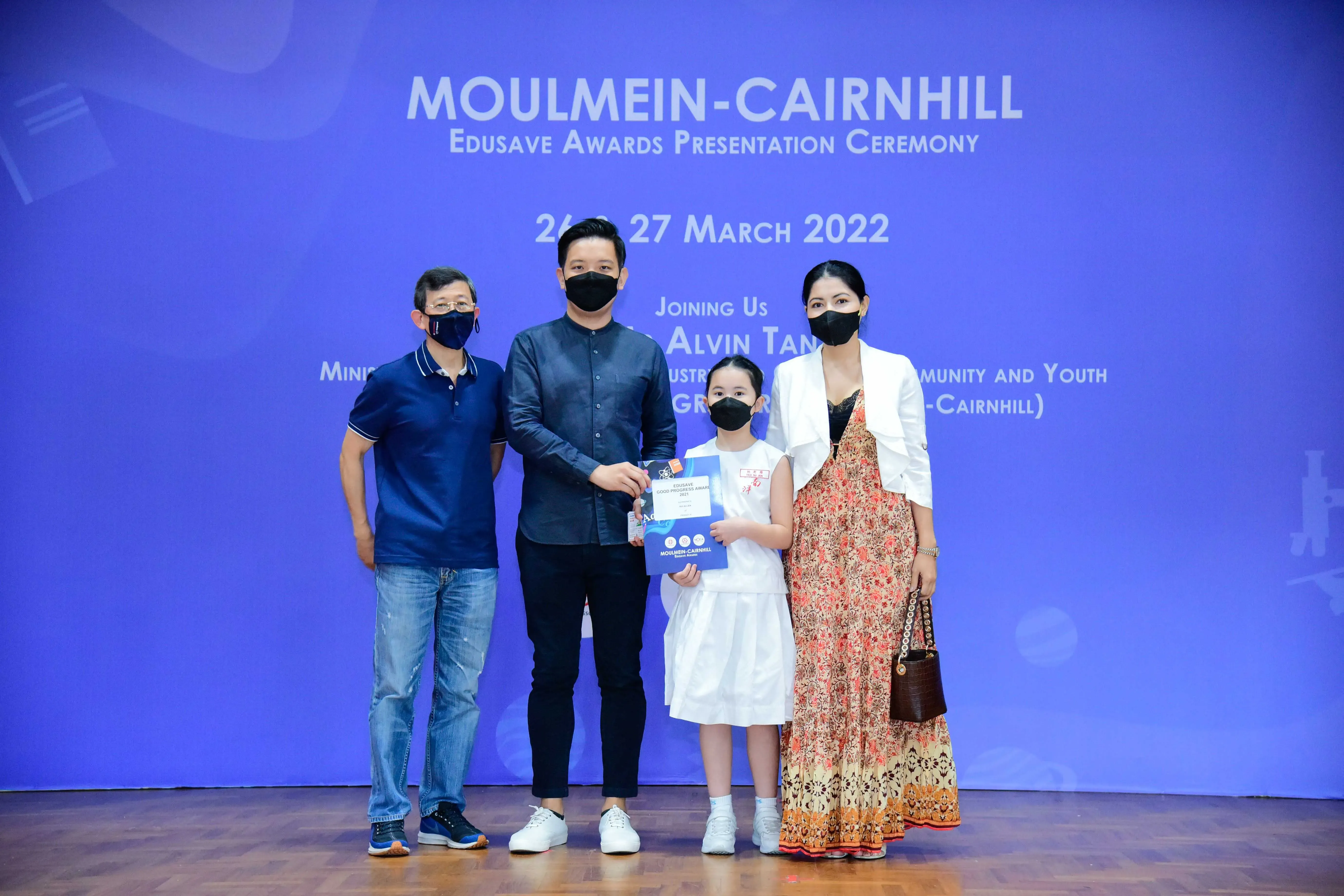Four masked people pose at the Moulmein-Cairnhill Edusave Awards Presentation Ceremony on 26-27 March 2022.