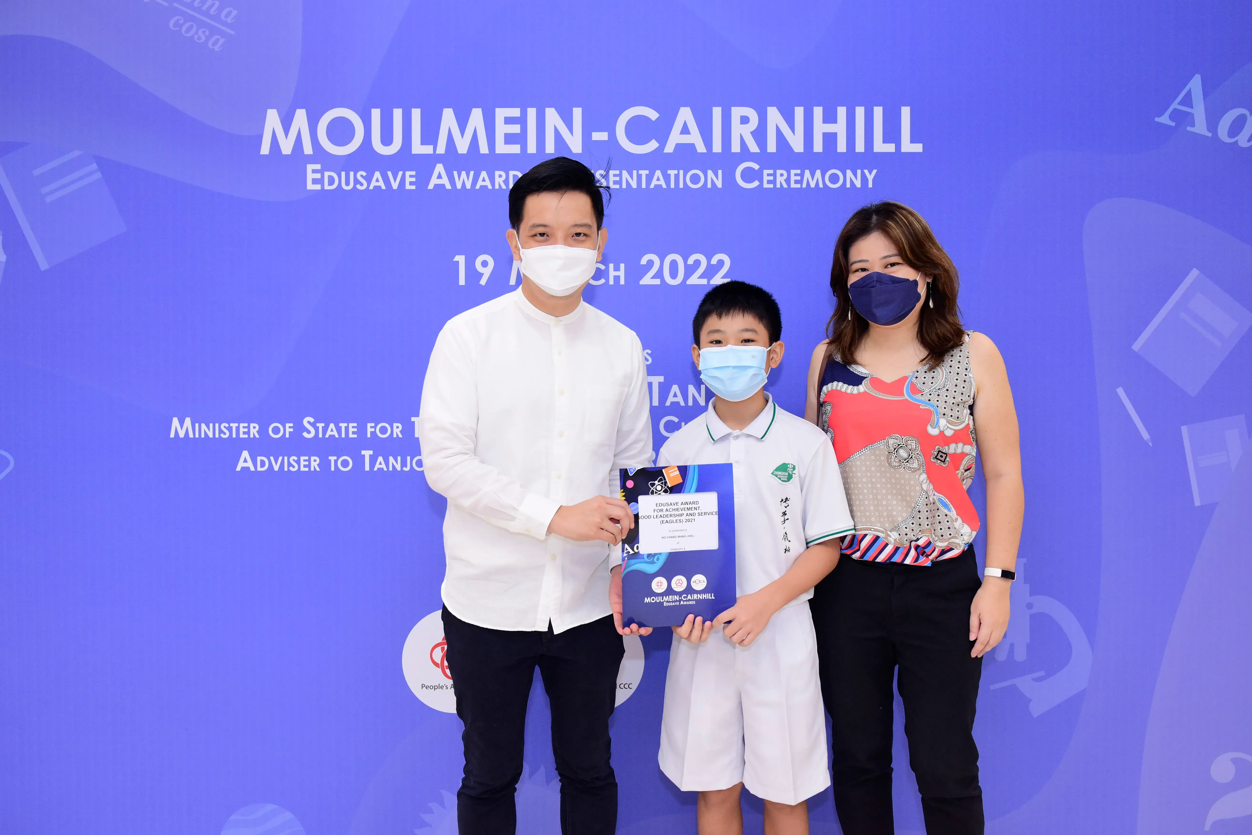 Three masked people pose at the Moulmein-Cairnhill Edusave Award Presentation Ceremony on 19 March 2022.