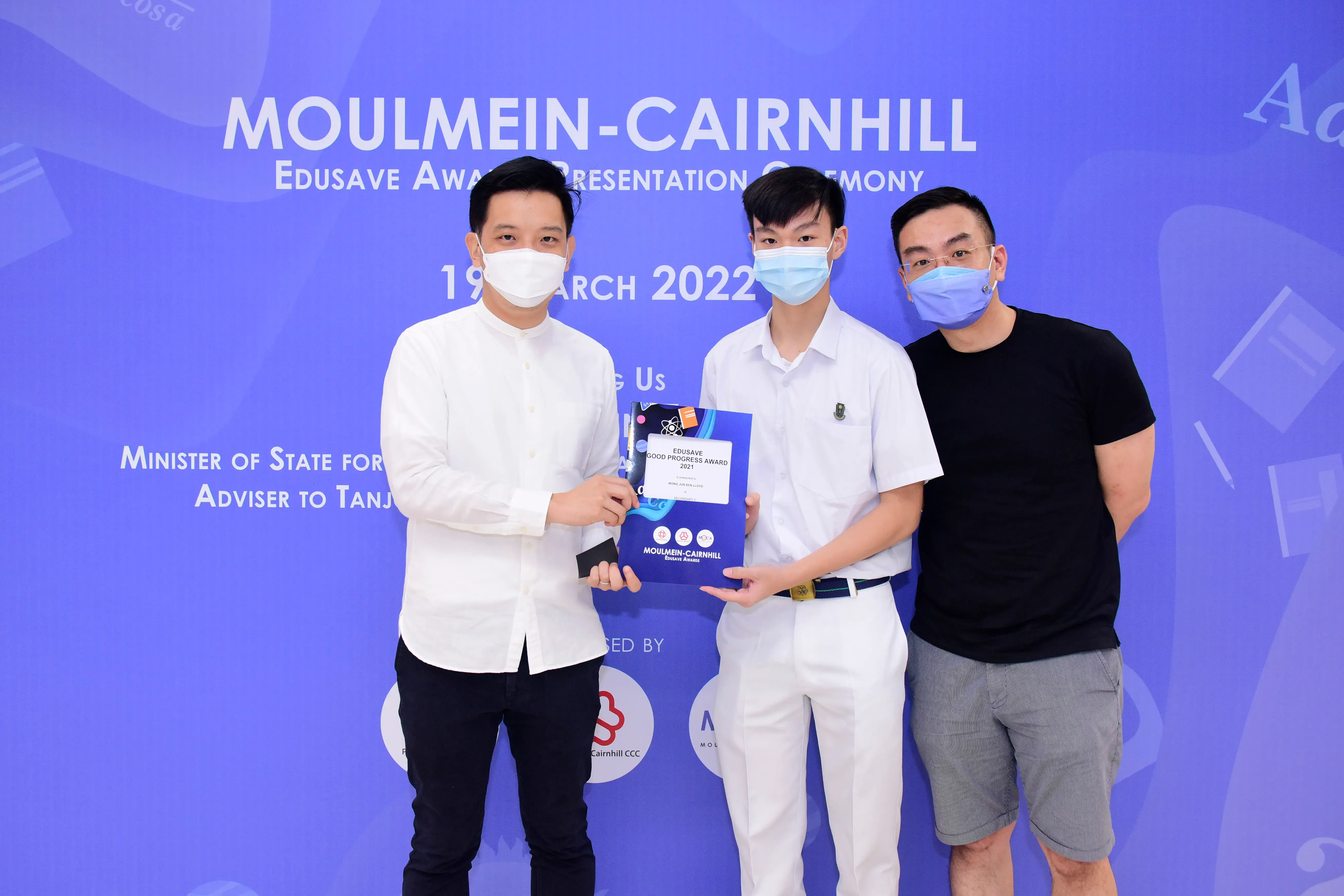 Three masked men pose at the Moulmein-Cairnhill Edusave Award Presentation Ceremony on 19 March 2022.