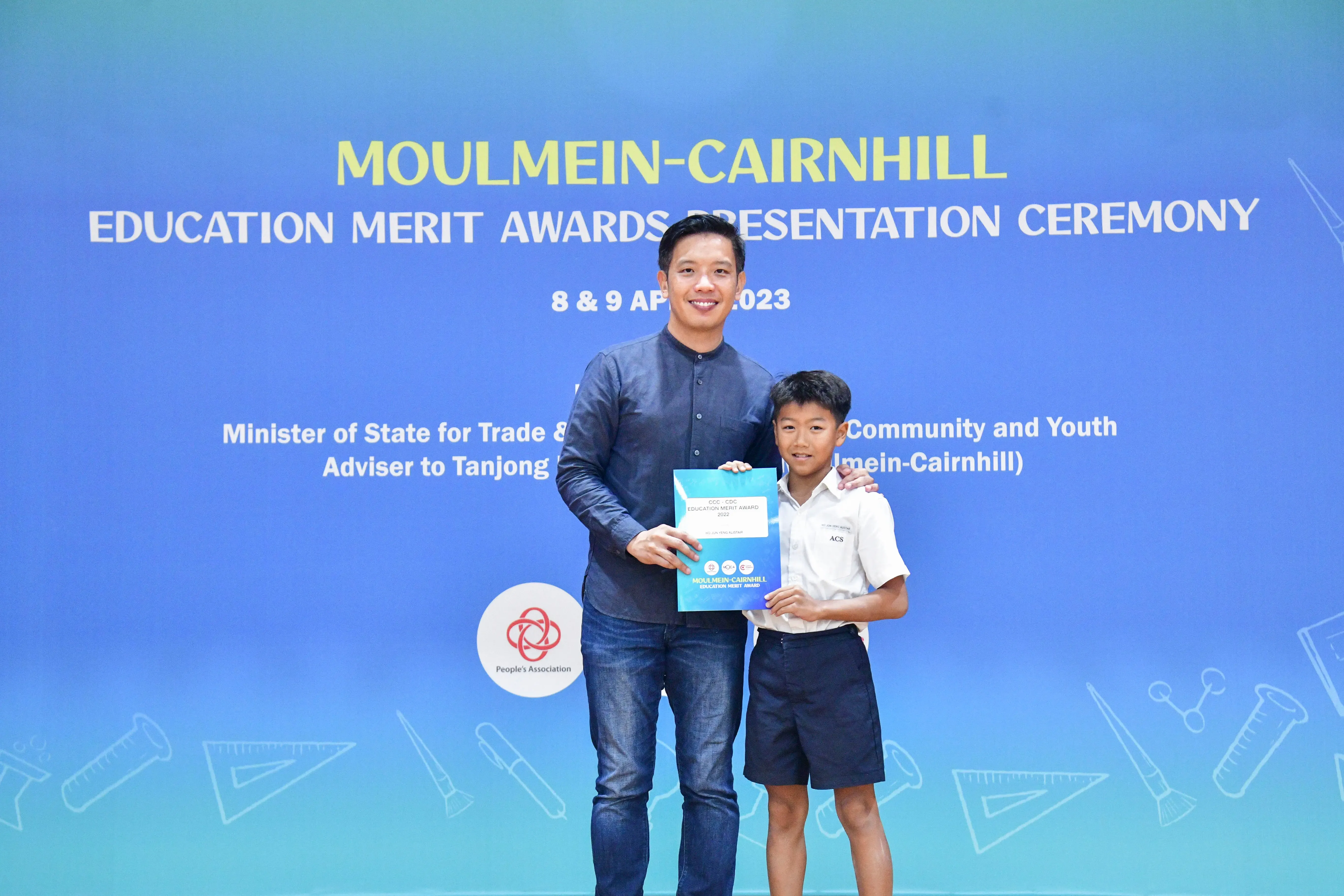 A man and a young boy pose together holding an award certificate at the Moulmein-Cairnhill Education Merit Awards 2023.