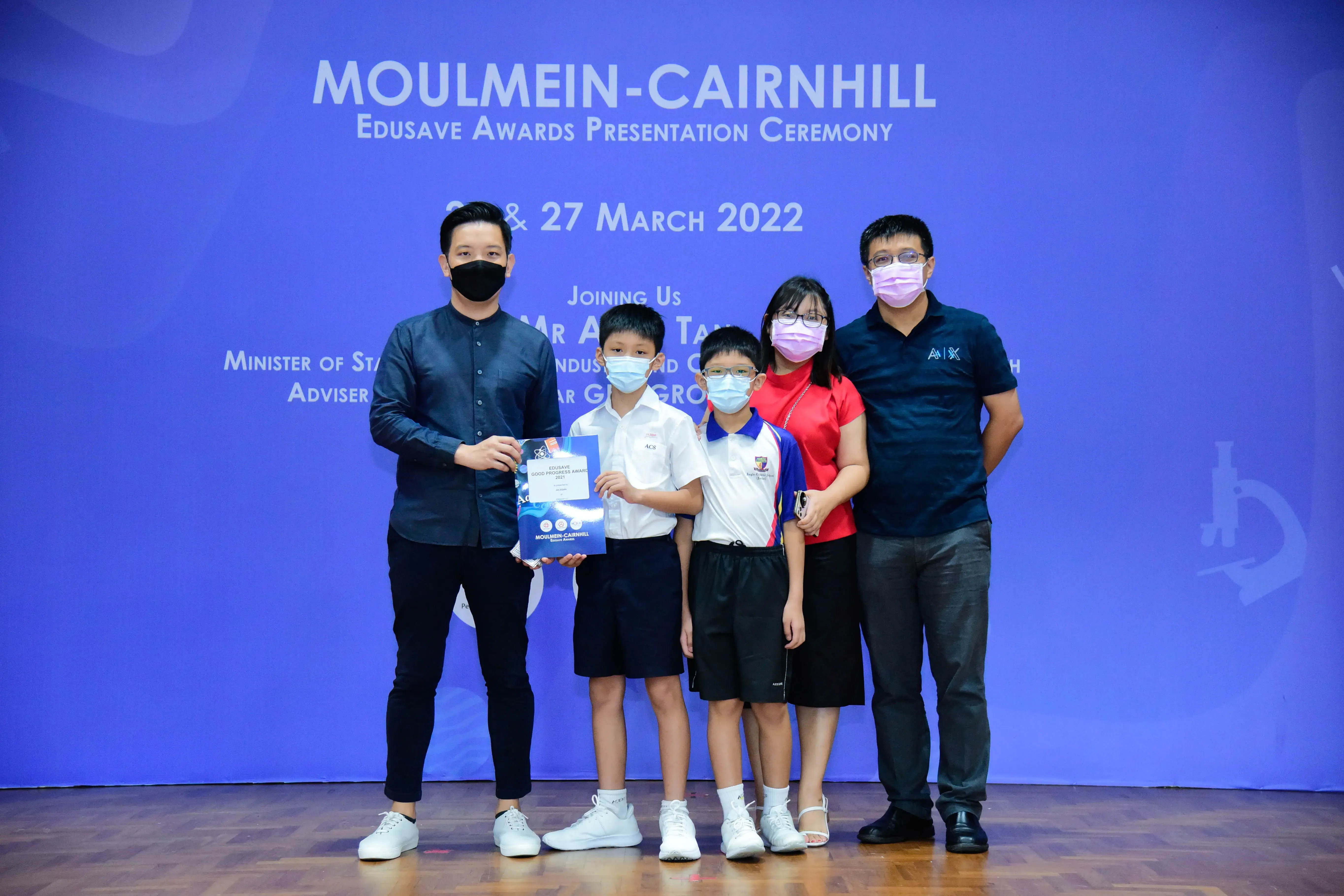 Five masked people pose at the Moulmein-Cairnhill Edusave Awards Presentation Ceremony on 27 March 2022.