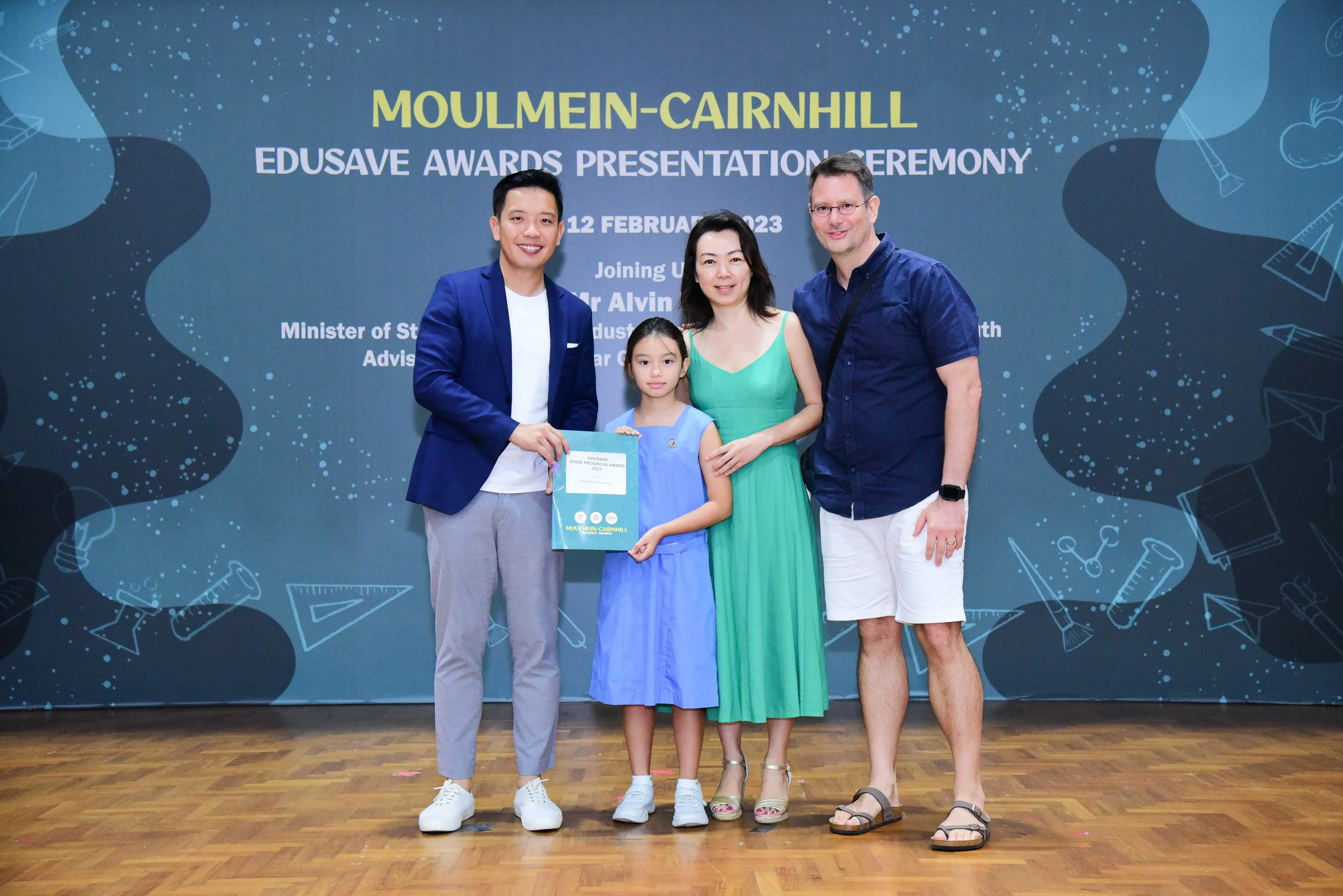 Four people pose at the Moulmein-Cairnhill Edusave Awards Ceremony; a girl holds a certificate.