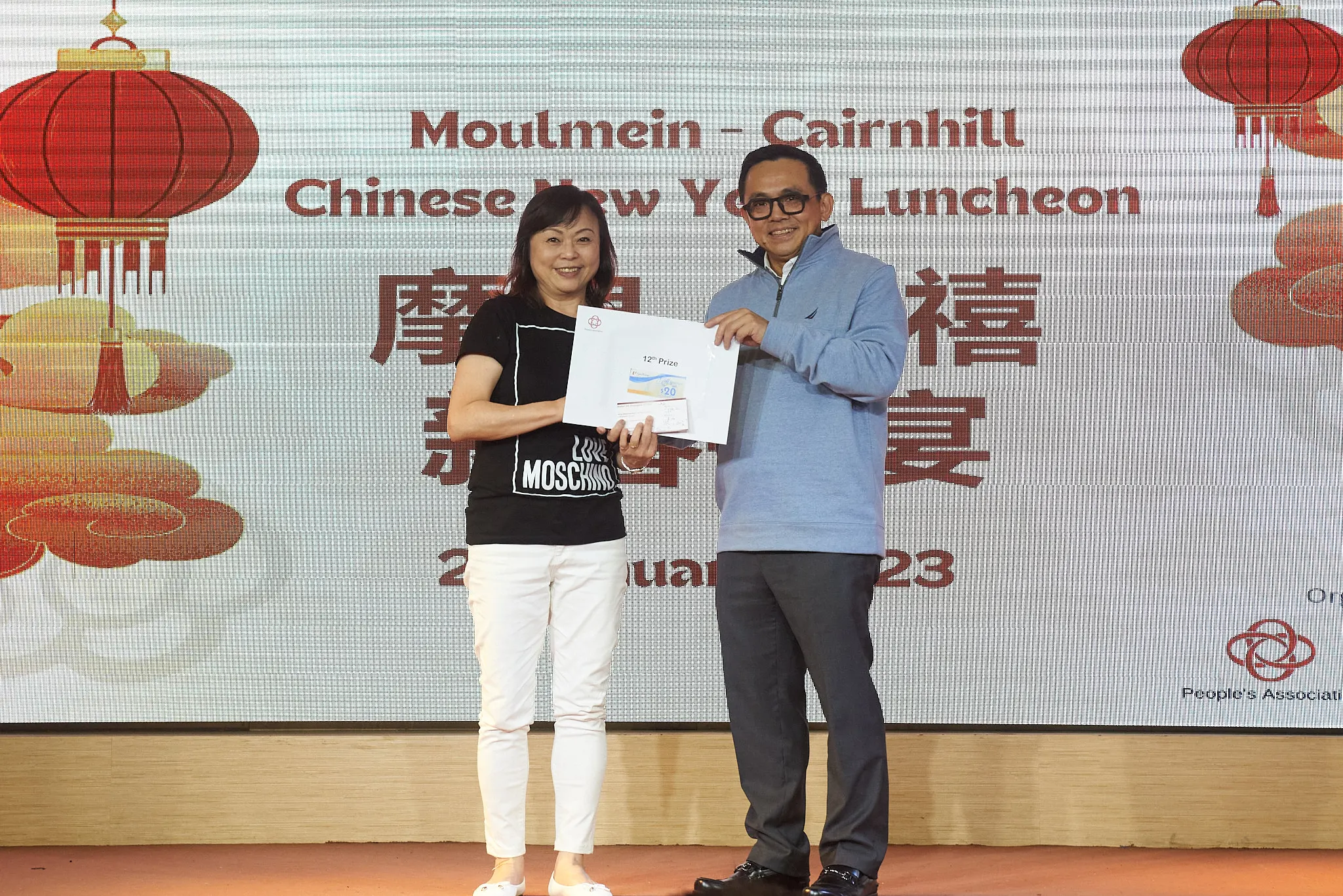 Two people hold a prize certificate at the Moulmein-Cairnhill Chinese New Year Luncheon 2023.