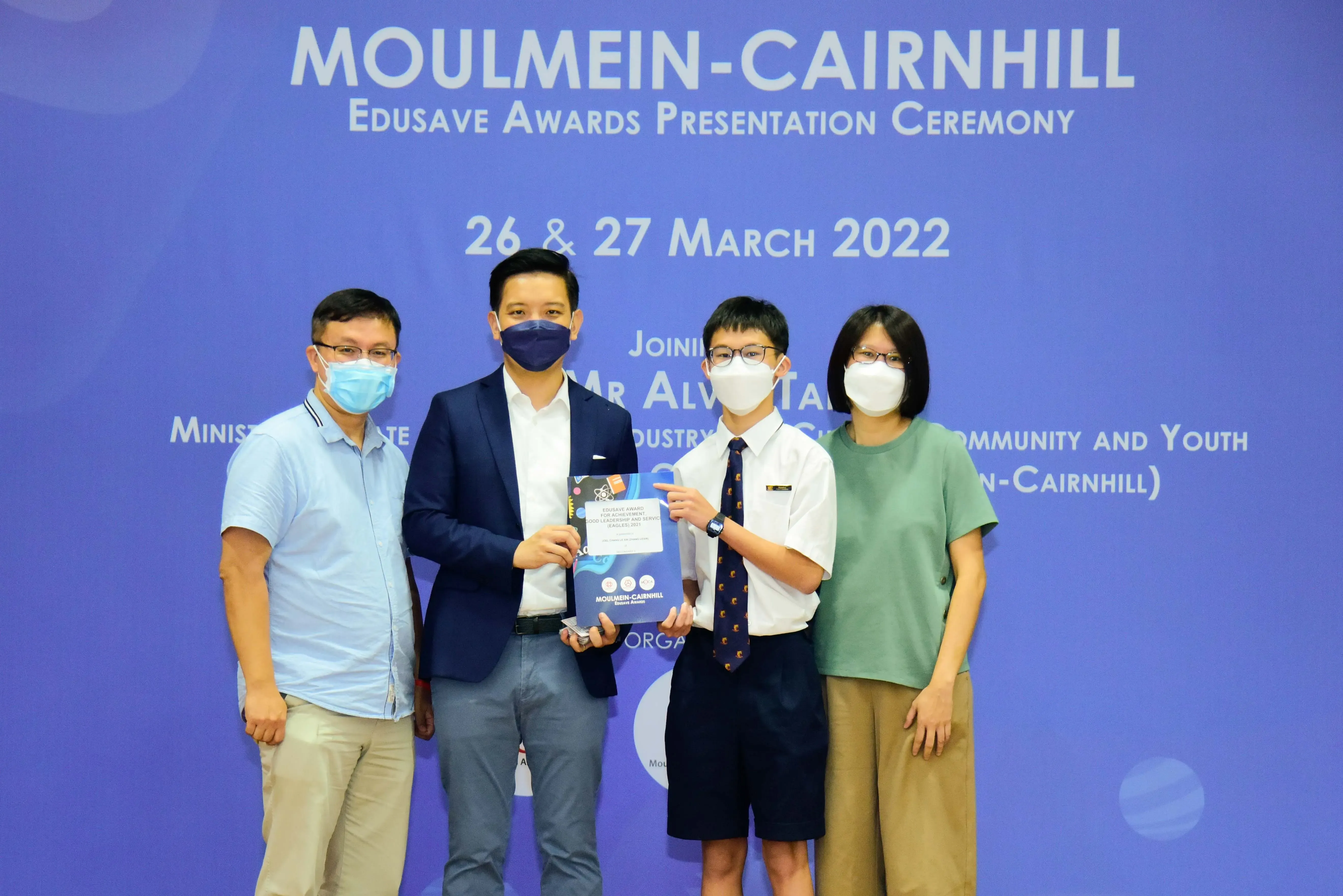 Four masked people pose at the Moulmein-Cairnhill Edusave Awards Presentation Ceremony on 26-27 March 2022.