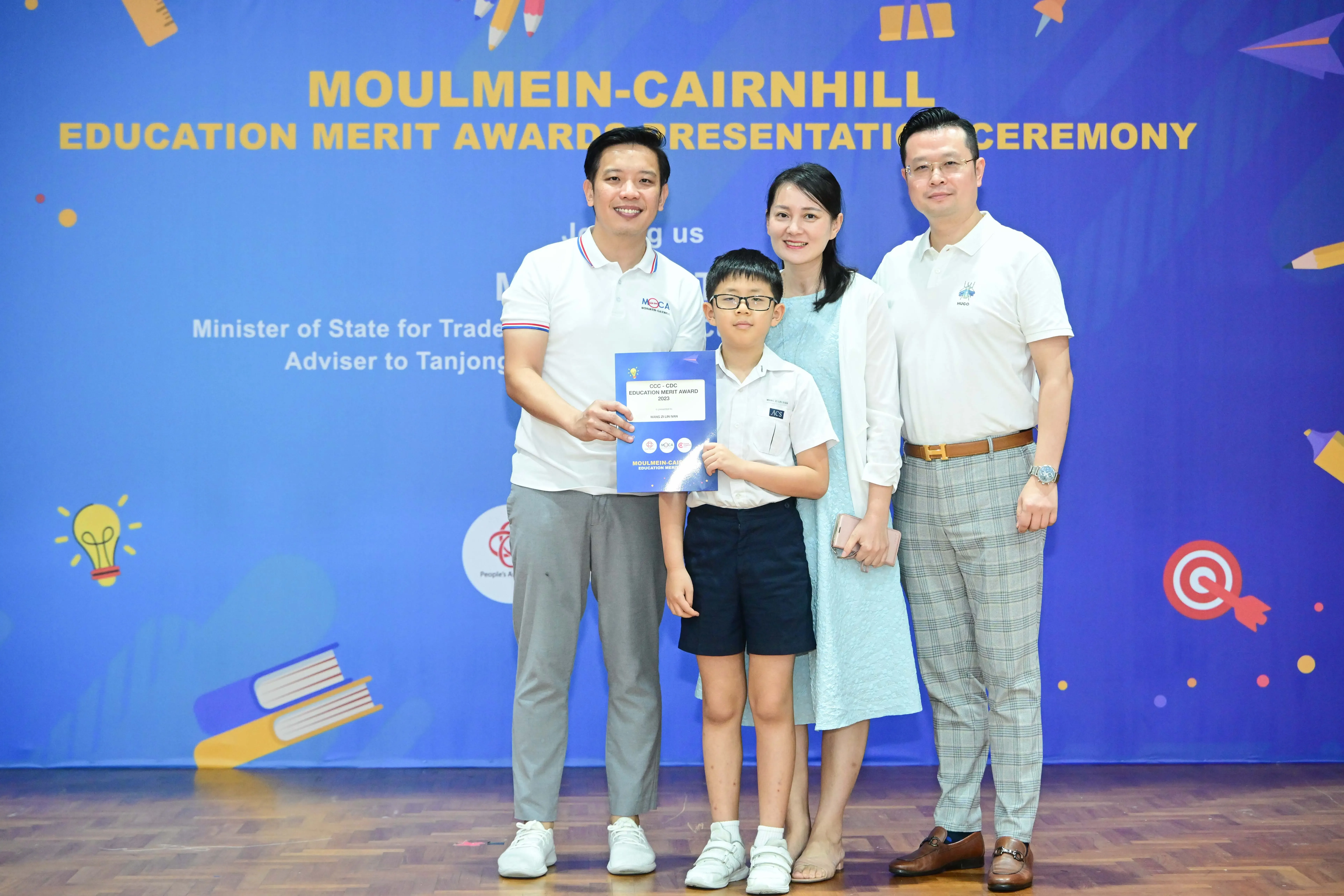 Four people pose with an award certificate at the Moulmein-Cairnhill Education Merit Awards Presentation Ceremony.