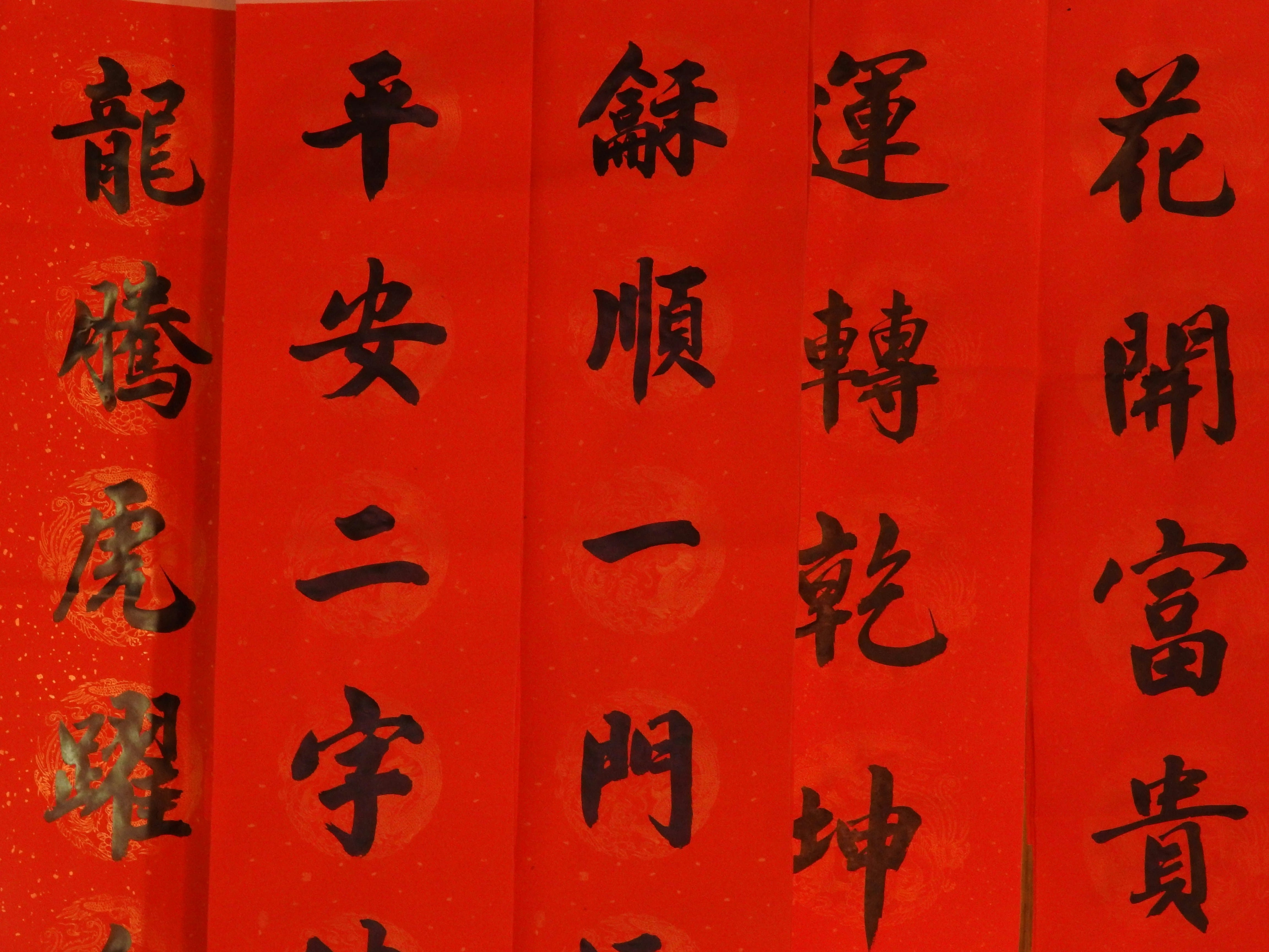 Red panels with black Chinese calligraphy characters arranged in vertical columns, typical of festive couplets.