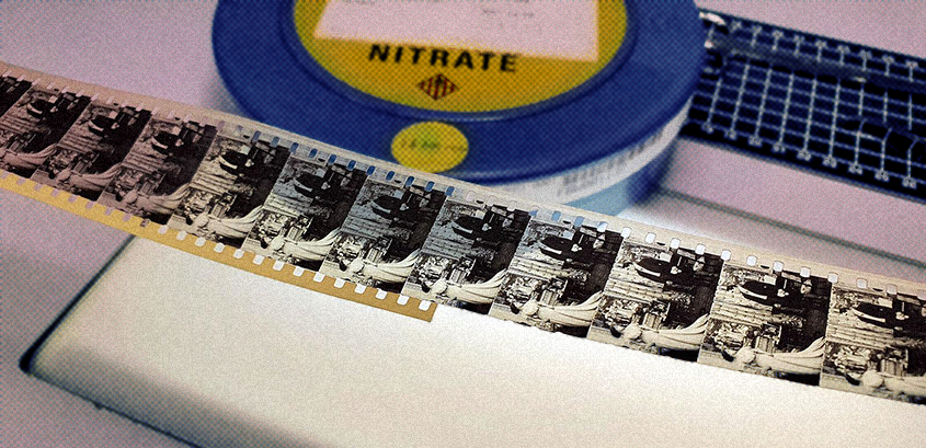 A strip of black and white film negatives lies in front of a blue reel labeled "NITRATE."