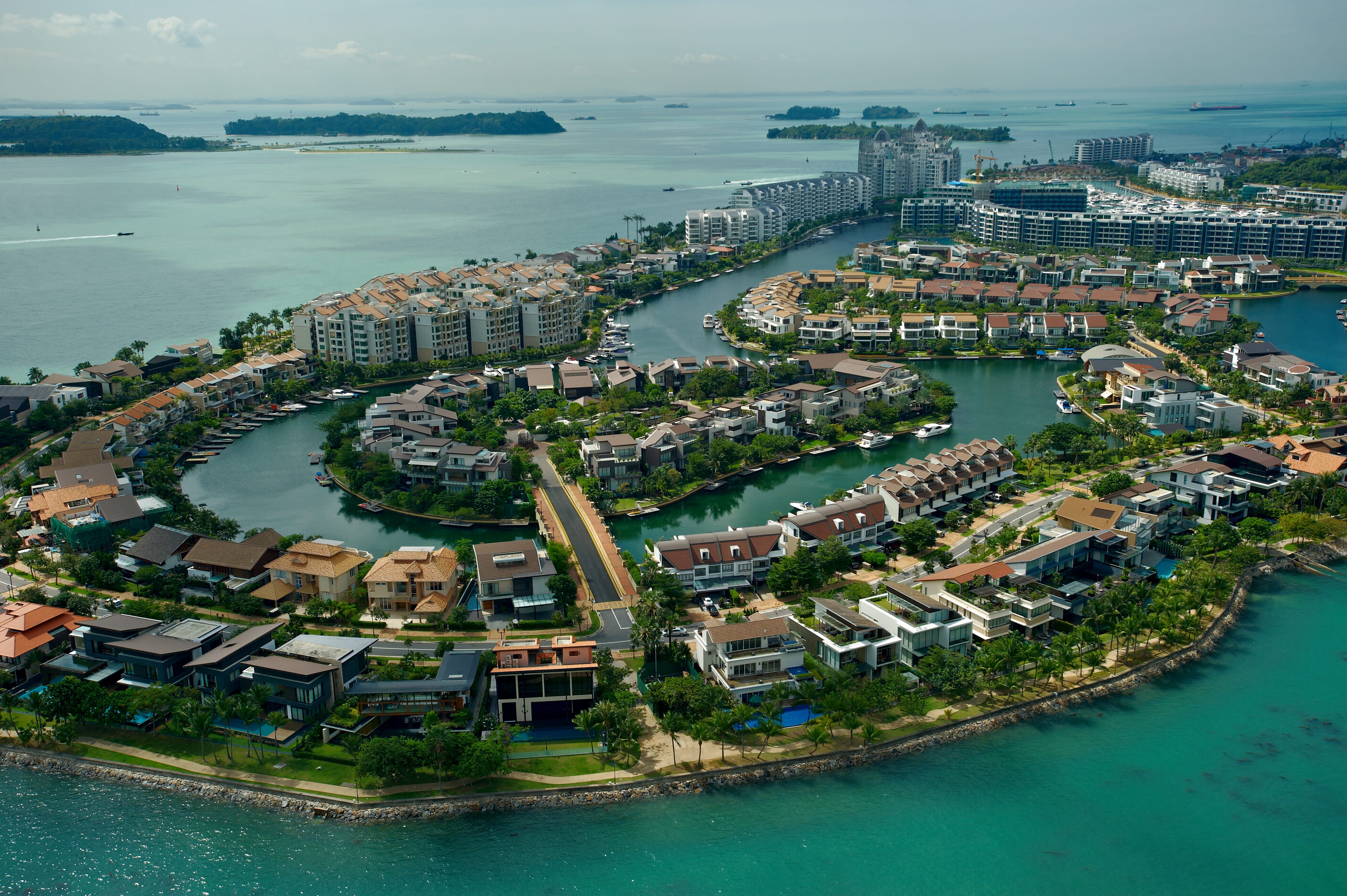 A bird's eye view of a waterfront development with residential buildings surrounded by the sea