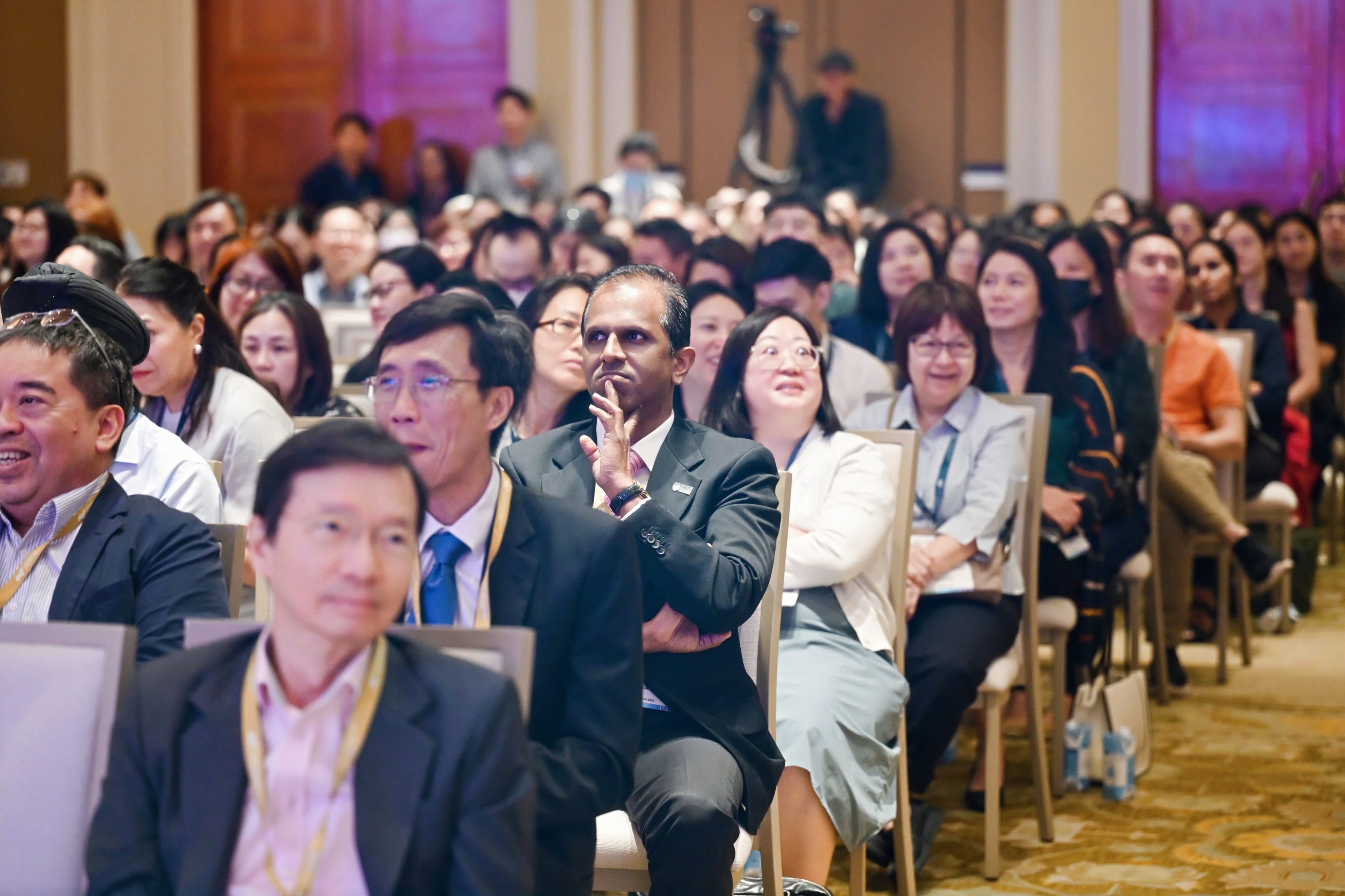 Delegates sitting on chairs, listening attentively to the conference