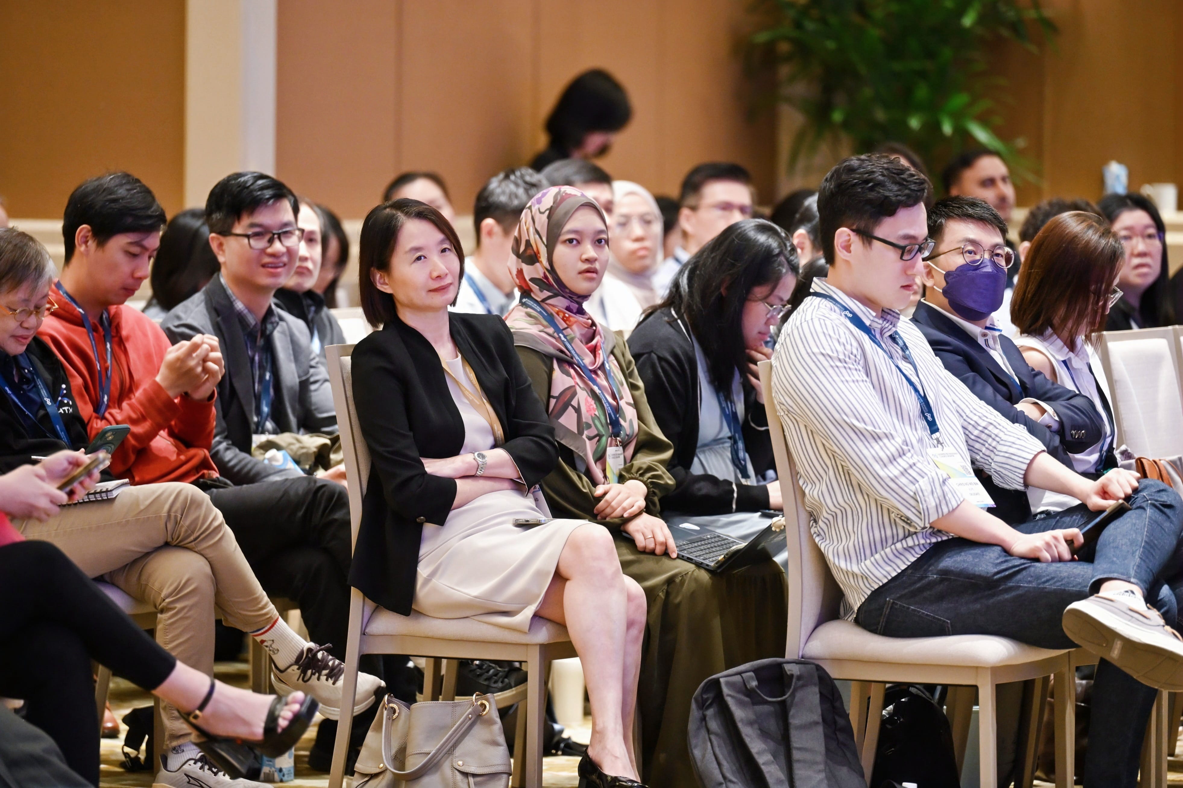 Delegates sitting on chairs, listening to the conference
