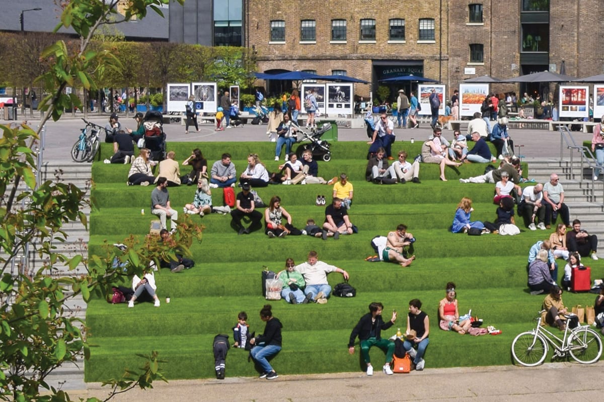 People sitting on the green steps at Granary Square