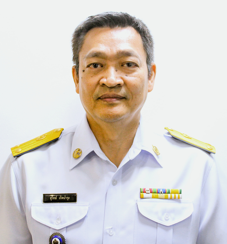 Man in a white uniform shirt with yellow epaulets and medal ribbons, facing camera against plain background.