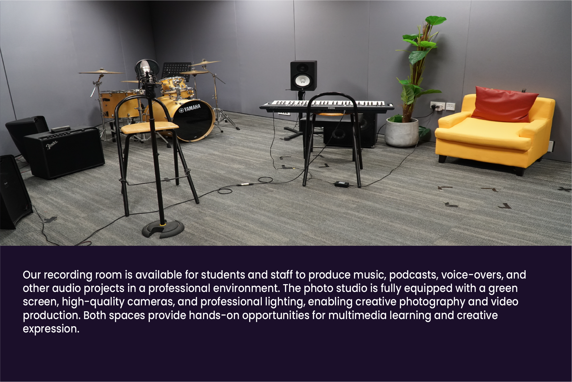 A music recording room with a Yamaha drum kit, keyboard, microphone stand, monitor speaker, and a yellow armchair.
