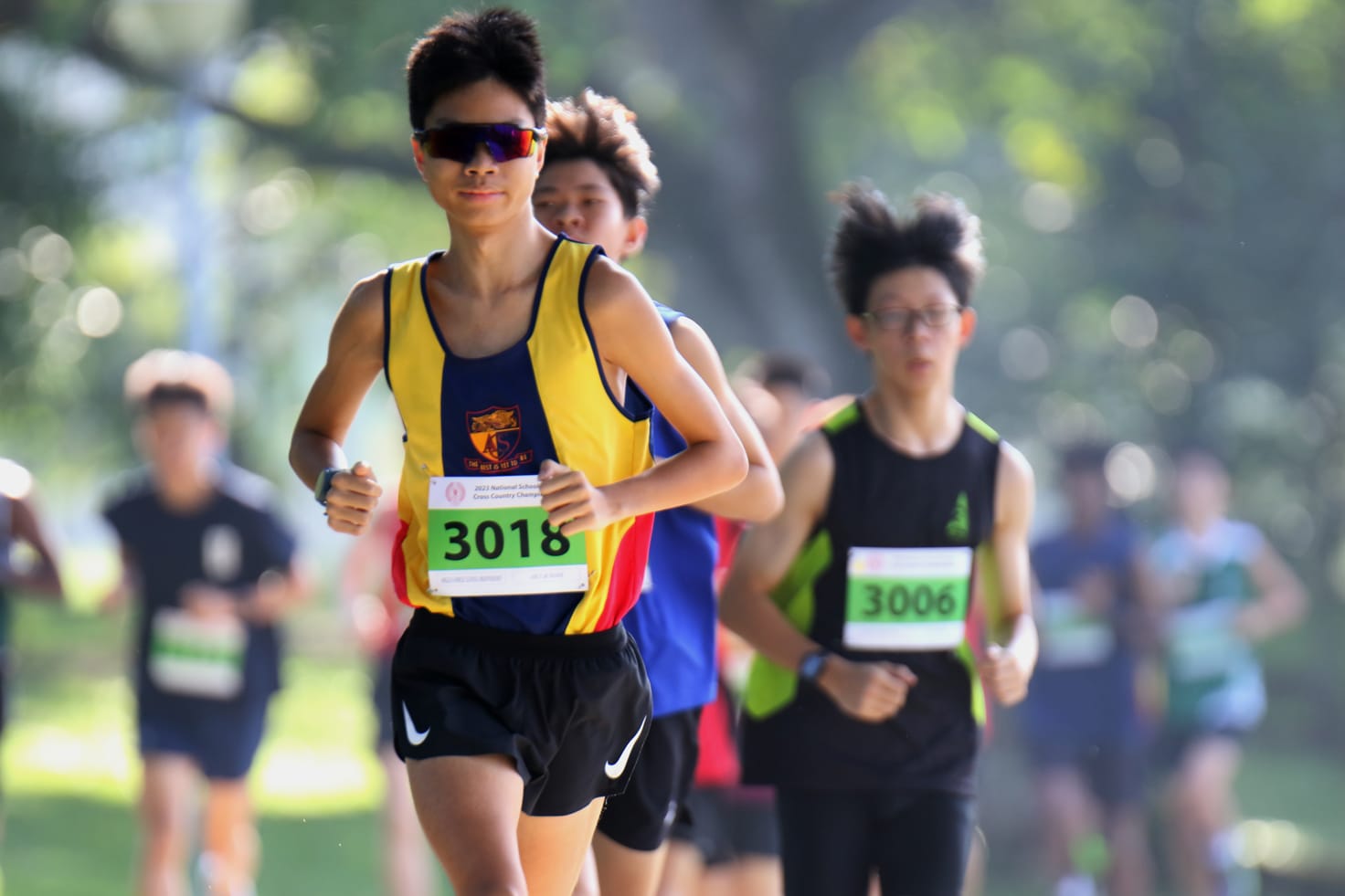 A runner in sunglasses smiling mid run