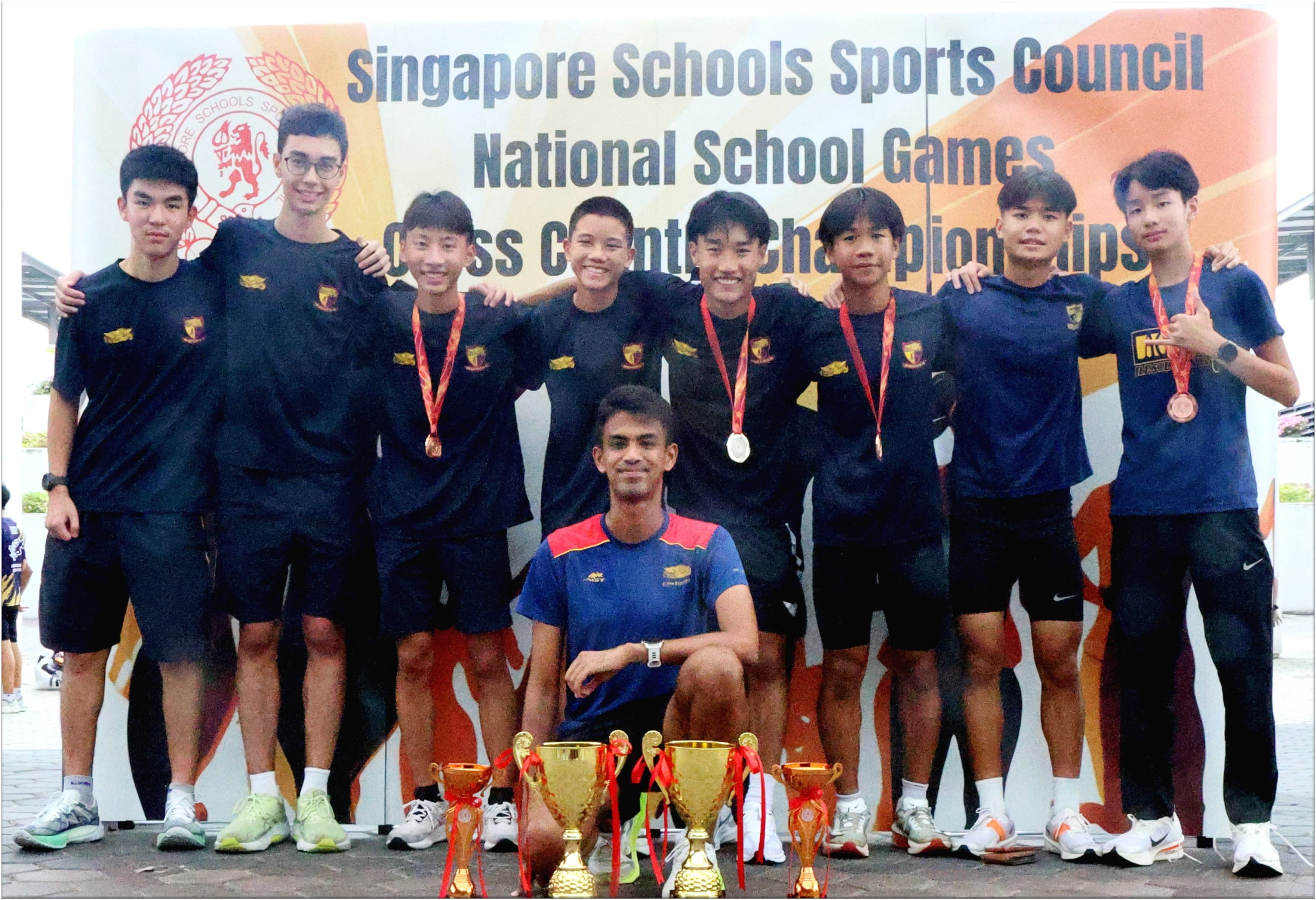 A school team poses with medals and trophies at the Singapore Schools Sports Council National School Games Cross Country Championships.