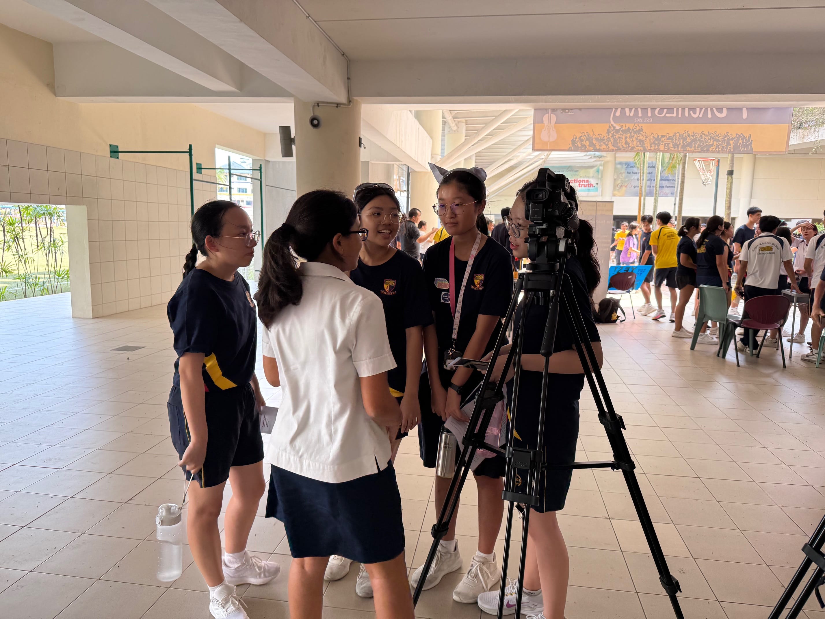 A group of students engaged in conversation in front of a camera