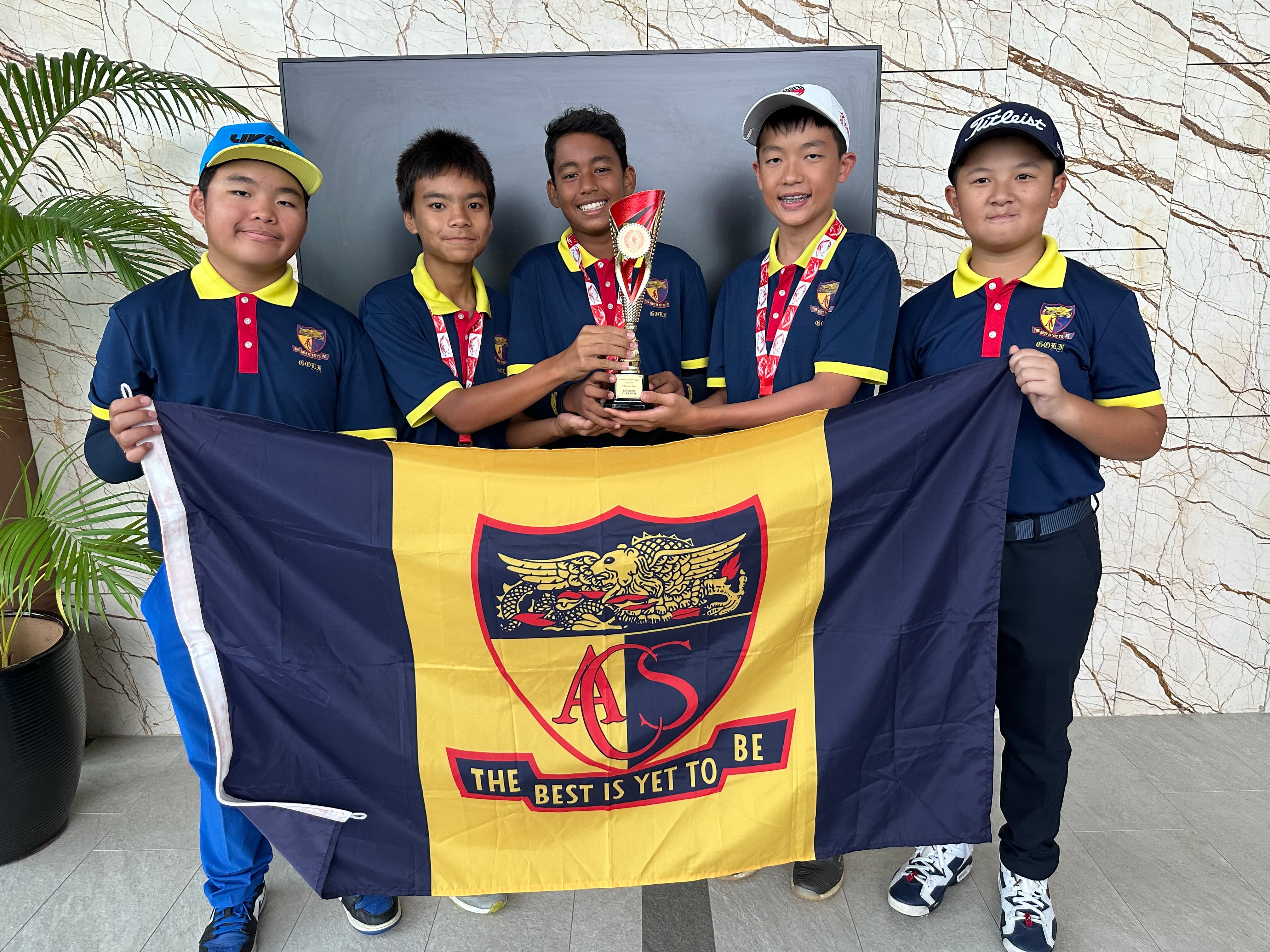 Five boys in navy and yellow golf uniforms hold a trophy and an ACS school flag reading "The Best Is Yet To Be."