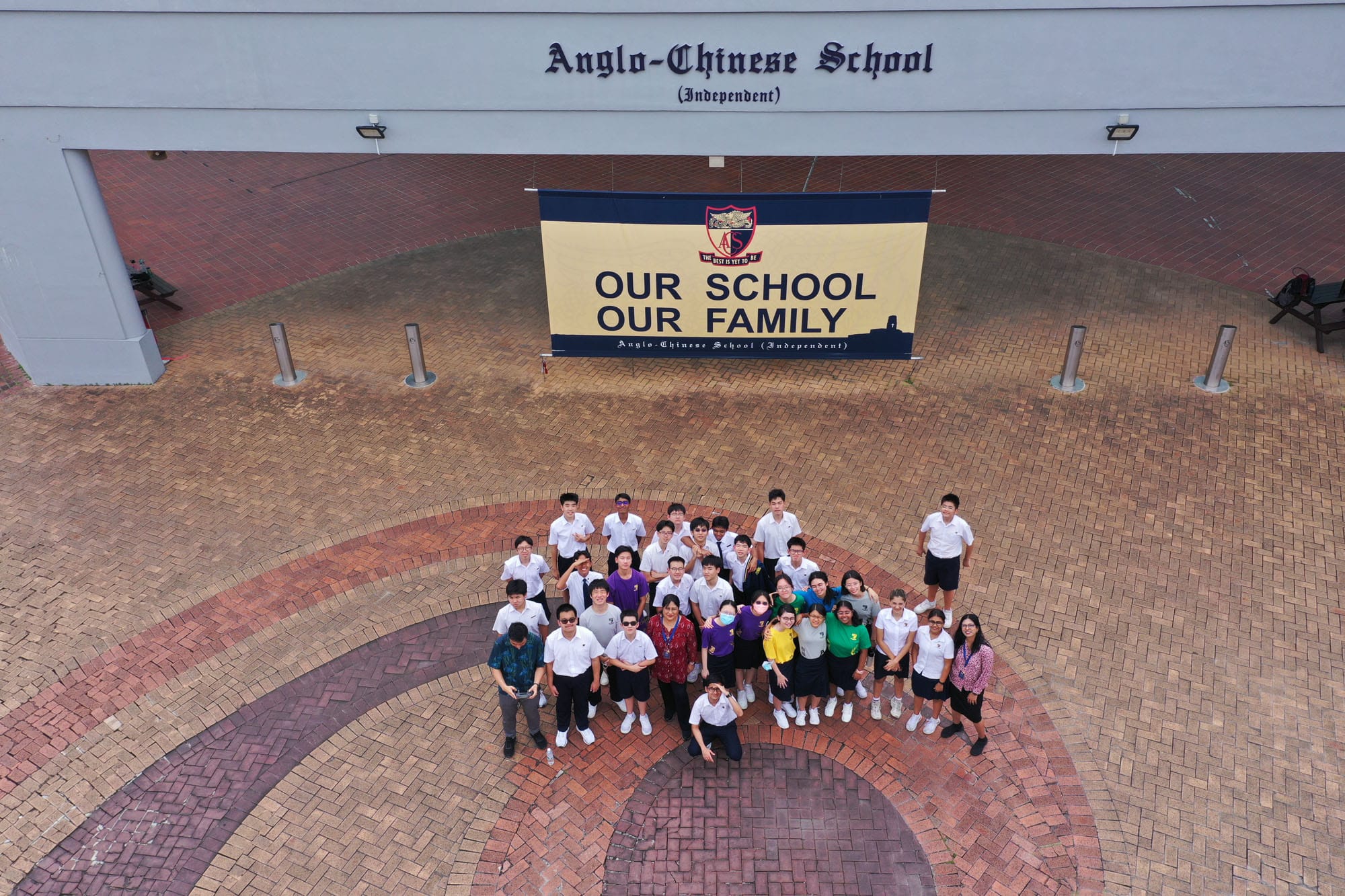 A group of students and their MPAC teachers posing for a far-away overhead drone shot