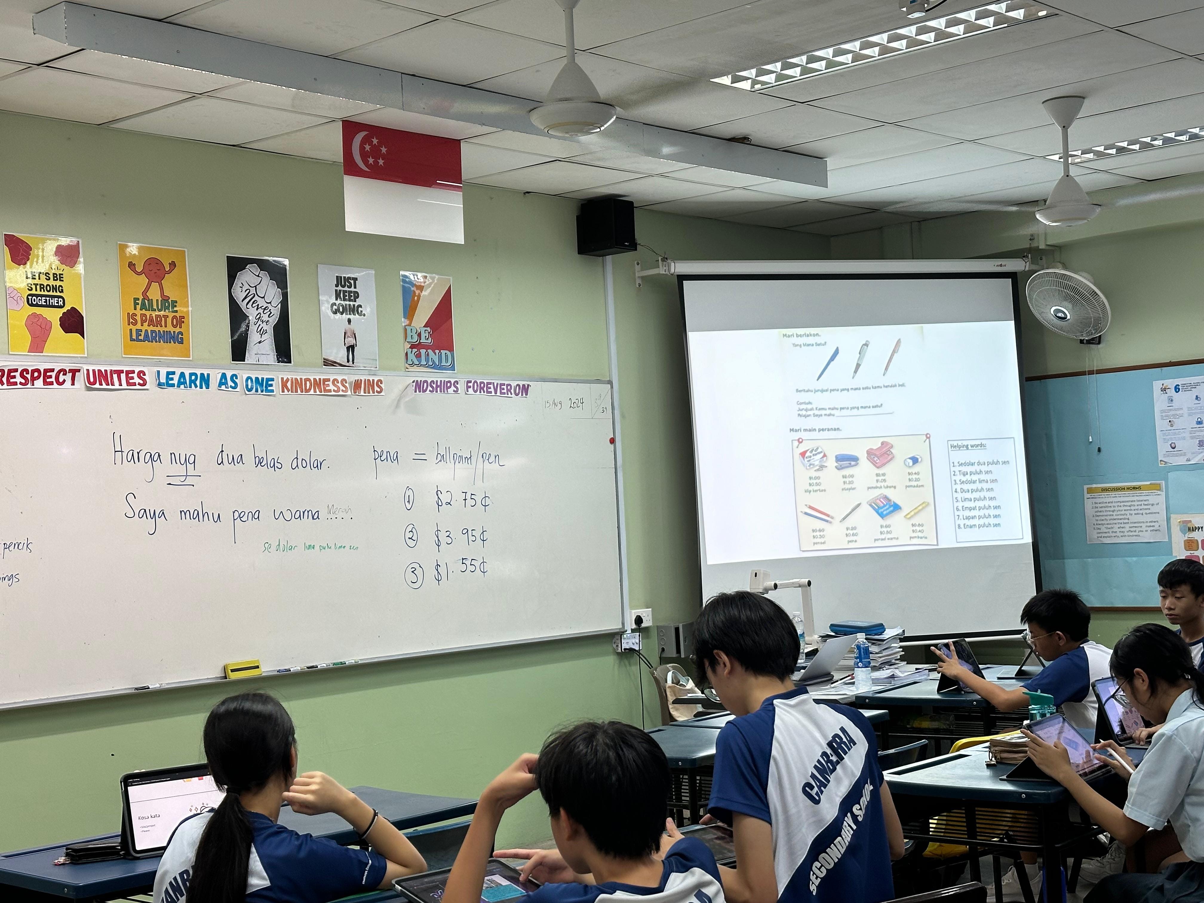 Students in a Singapore secondary school classroom with tablets, facing a whiteboard and projected lesson slide.