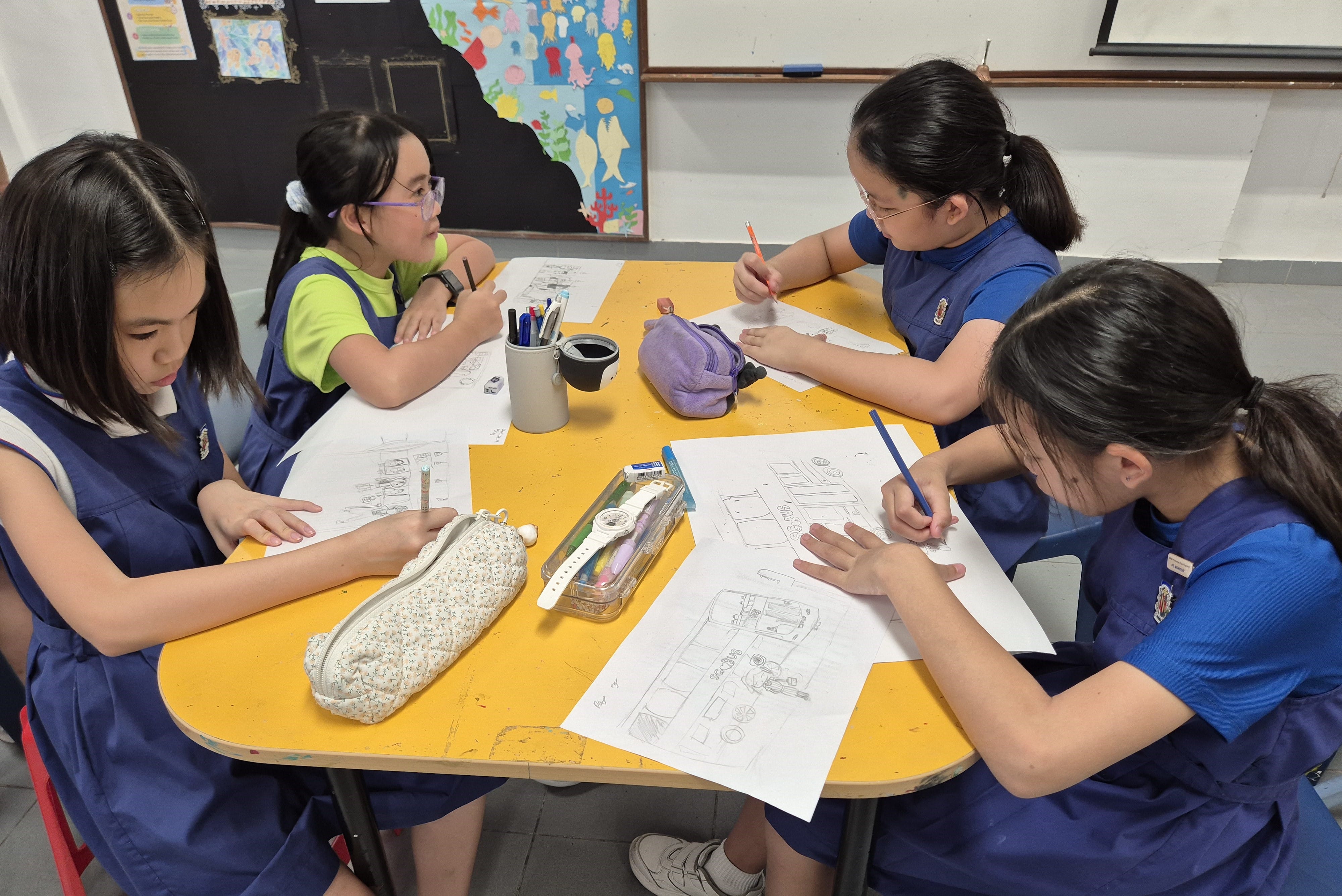 Art Club students sketching on large sheets of paper during their CCA.