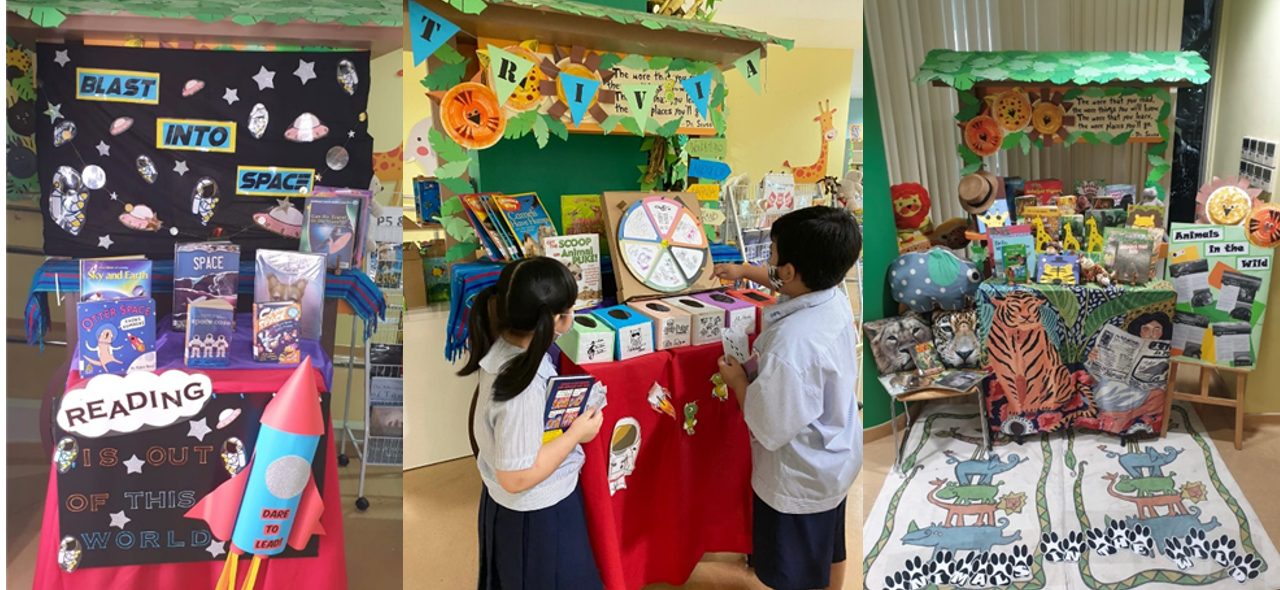 Three school reading fair booths on space, animal trivia, and wildlife, with two children spinning a wheel at the middle booth.