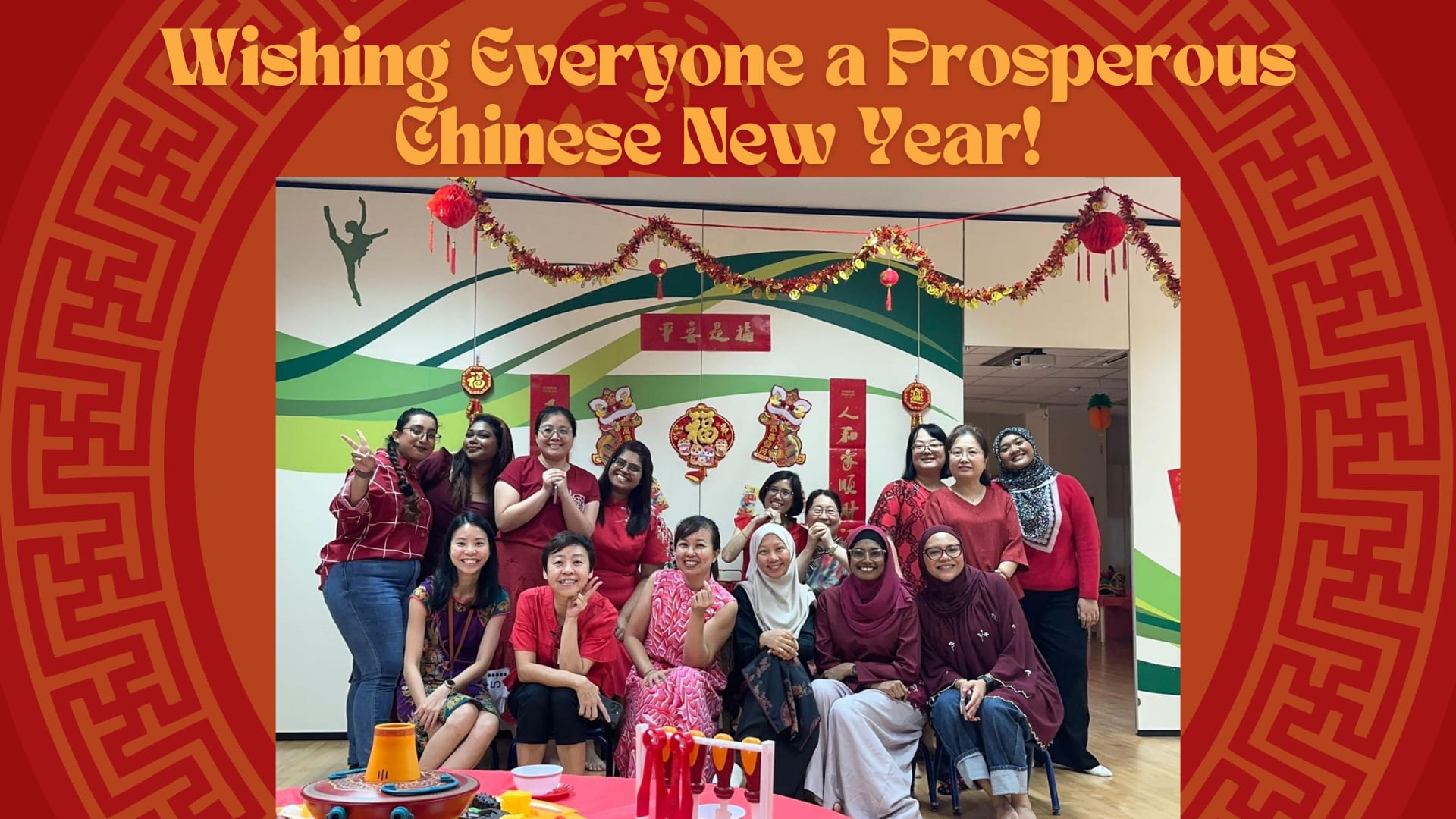 Group of women posing in a festively decorated room with Chinese New Year ornaments and red text greeting above.