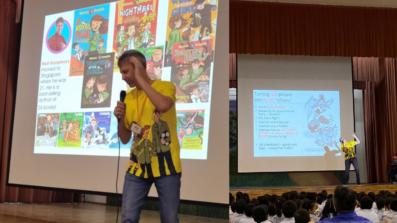 A man in a yellow shirt holds a microphone and presents about author Neil Humphreys and his books to a school audience.