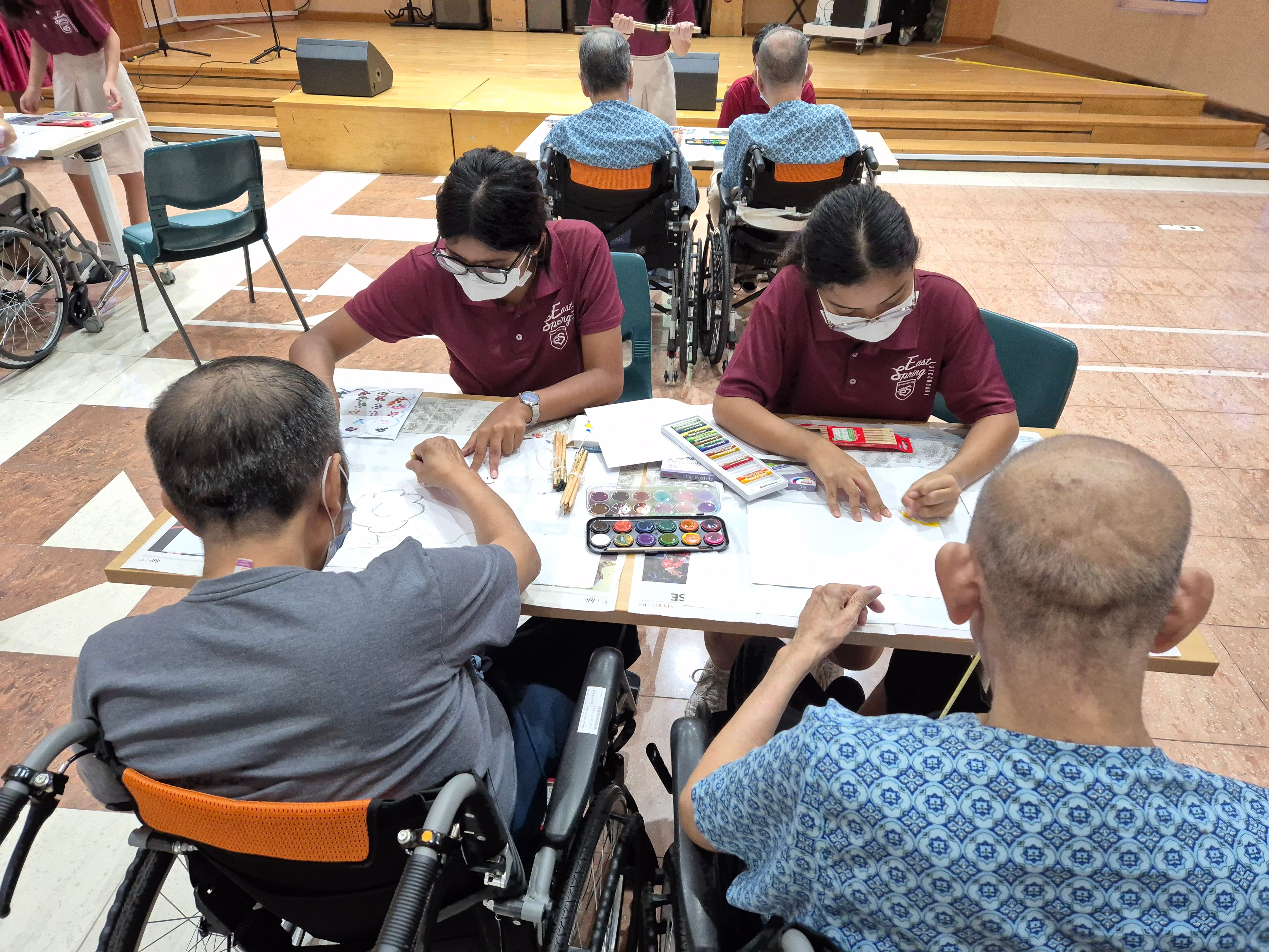 student engaging eldery in art work