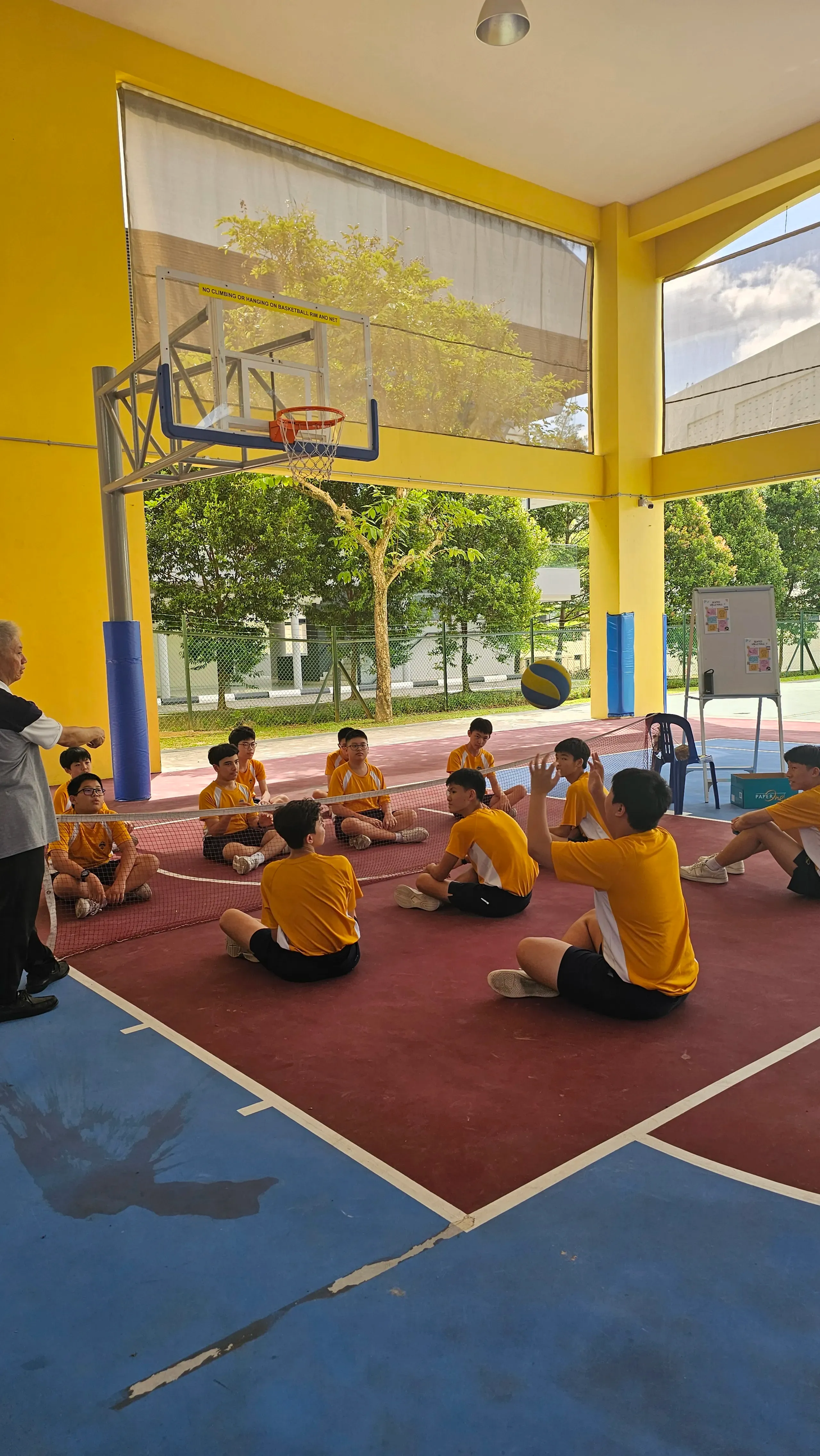 Secondary 2 Fairsians playing sitting volleyball during a Diff-Ability Day simulation.