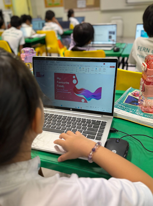 P2 learners developing Communication and ICT skills through PowerPoint presentations about themselves.