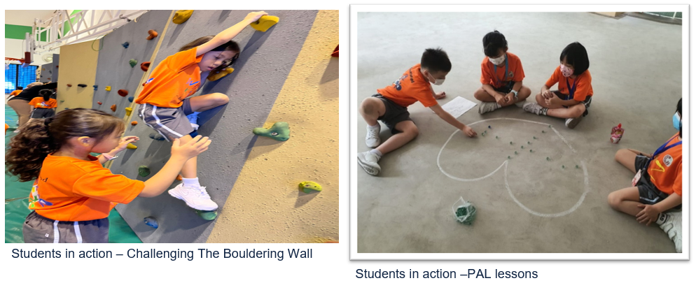 Students in orange shirts climb a bouldering wall while others sit on a floor playing a circle game.