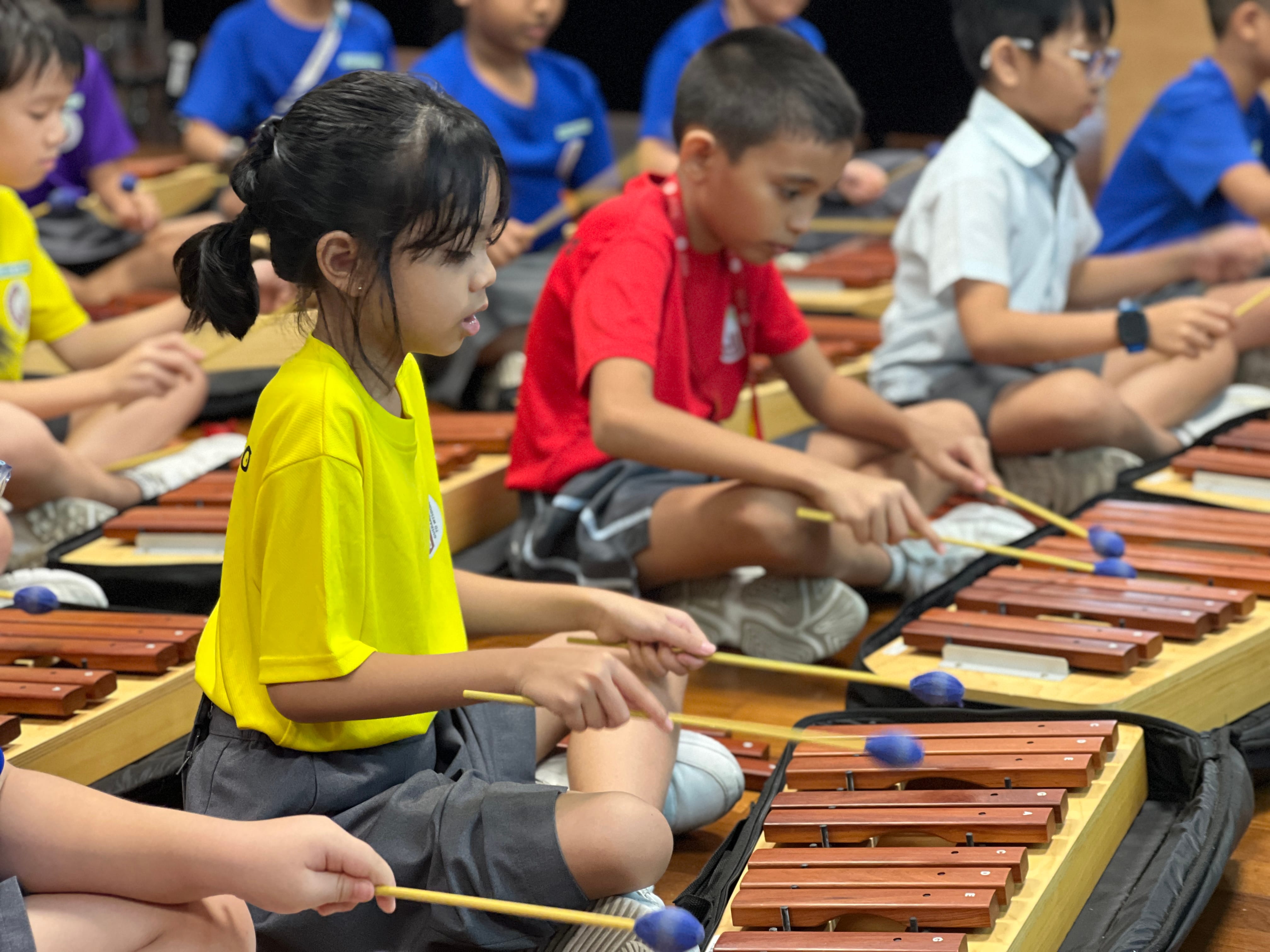 Group of students playing wooden xylophone
