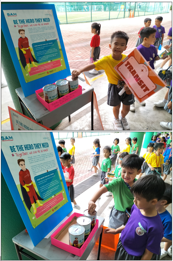 Children dropping coins into donation tins at a SAM "Be The Hero They Need" charity booth outdoors.